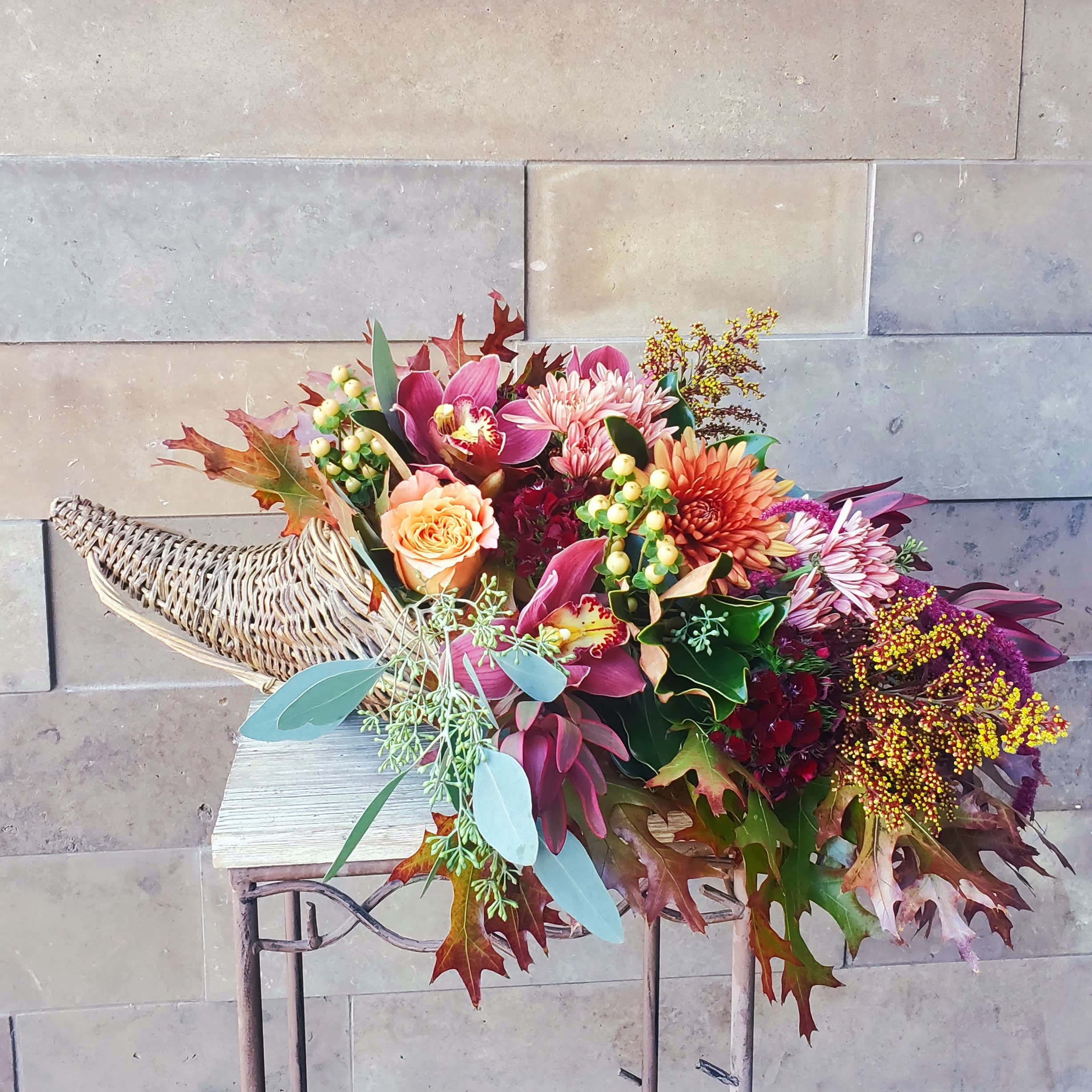  Cornucopia, a holiday tradition  - Overflowing with fall leaves,  berries and premium, long lasting flowers. Such as orchids,  mums and roses. Approx. 20 inches. 