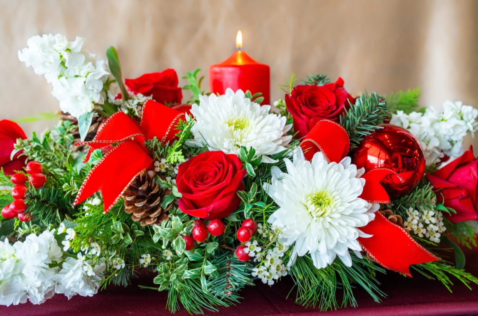 Home for the Holidays - Whether you are home for the holidays or sending this gift from afar, consider a classic combination of lush blooms and winter greens, vivid red roses, ribbons and festive ornaments, toped with a long-lasting pillar candle. This will surely set the stage for any gathering this holiday season! 