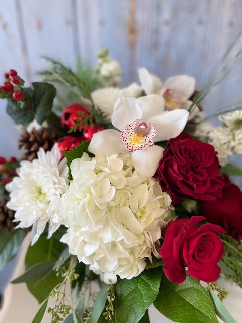 Must Be Santa - They will think Santa himself must have brought this gorgeous styled centerpiece of Hydrangea, roses, orchids, vivid berries, ornaments, cones and fresh wintergreens. Send this gift with love today!   Available for delivery from November 25th through the Holiday Season.  