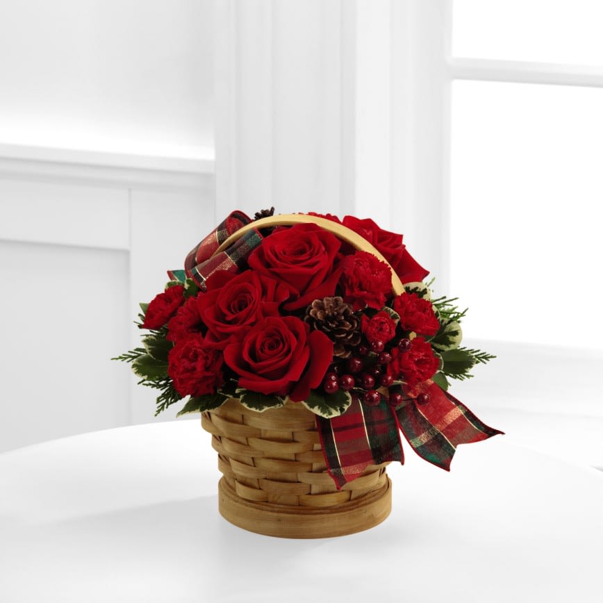  Joyous Holiday Bouquet - The Joyous Holiday Bouquet will greet your special recipient with seasonal beauty and blessings. Red roses and mini carnations are gorgeously arranged in a natural wood chip basket amongst assorted holiday greens, natural pine cones, and berry pics, accented with a tartan plaid ribbon to create a gift that wishes everything this wondrous season has to offer. 