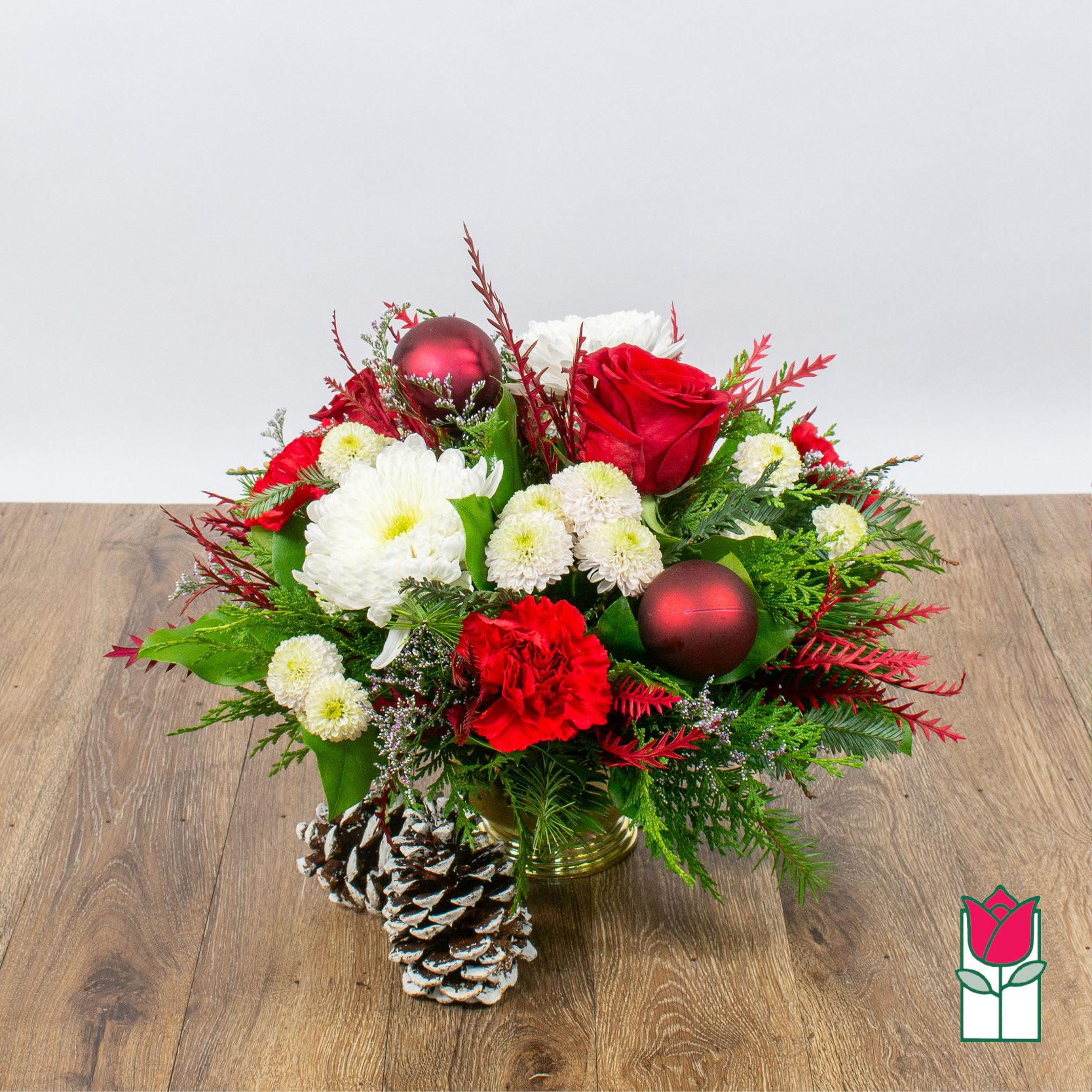Beretania's Seasons Greetings Centerpiece (Seasonal Flowers Vary) - Introducing the enchanting Christmas Floral Collection at Beretania Florist, where the spirit of the season blossoms with every petal. Our commitment to quality shines through in every handcrafted arrangement, making each piece a masterpiece of fresh premium flowers and a variety of fragrant Christmas greens.  Embrace the magic of the holidays with our exquisite Christmas floral items. While the final creation may showcase a unique selection of fresh blooms and foliage, the end result is guaranteed to resemble the stunning product photos on our website. Each arrangement is thoughtfully designed to capture the essence of Christmas, whether you prefer the traditional reds and greens or a more modern interpretation of the season.  At Beretania Florist, we understand the importance of timely delivery during the holiday rush. That's why we offer fast and reliable delivery services in the Honolulu area, ensuring your festive arrangements arrive at their destination in perfect condition. Additionally, for those who prefer a more hands-on approach, we offer free local pickup for your convenience.   Experience the joy of Christmas with the elegance and charm of our Christmas Floral Collection. Trust Beretania Florist to provide you with the freshest, most captivating floral arrangements, and make this holiday season truly unforgettable. Place your order today and let us help you celebrate the magic of Christmas in style.
