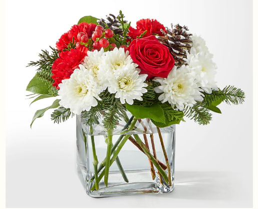 Snow Angel Bouquet - A delicate balance of red and white florals accented with seasonal greens to brighten their day. Details The Premium Bouquet is approximately 10&quot;H x 12&quot;W. Designed by florists, ready to display. For long–lasting blooms, replace the water daily. We suggest trimming the stems every couple days. Bloom Details: Carnations, Roses, Hypericum Berry, Christmas Greens