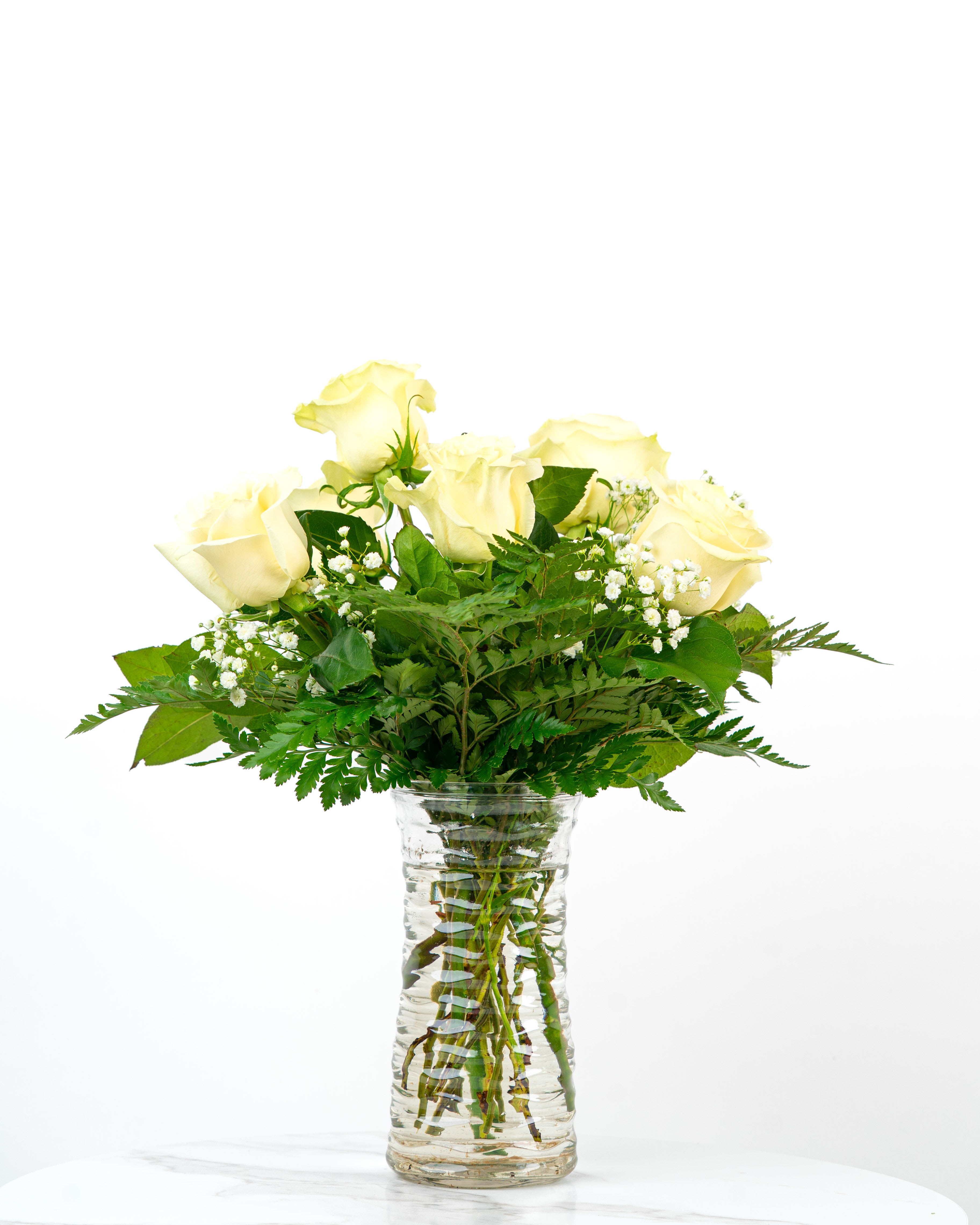 Our Rose Collection: White Roses Arrangement - Looking for a classic and charming arrangement of white roses to celebrate someone special? Let us express your friendship, support, and more with a half dozen (standard), dozen (deluxe), or two dozen (premium) white roses from our Rose Collection.   At Schultz Floral, each arrangement is one of a kind and styled just for your order in our Valpo Shop. Because we always use the freshest blooms, your final rose arrangement may not look exactly as pictured due to rose variations and availability. However, rest assured - this white rose arrangement with greens continues to amaze all Valparaiso enthusiasts, graduates, athletes, and artists.