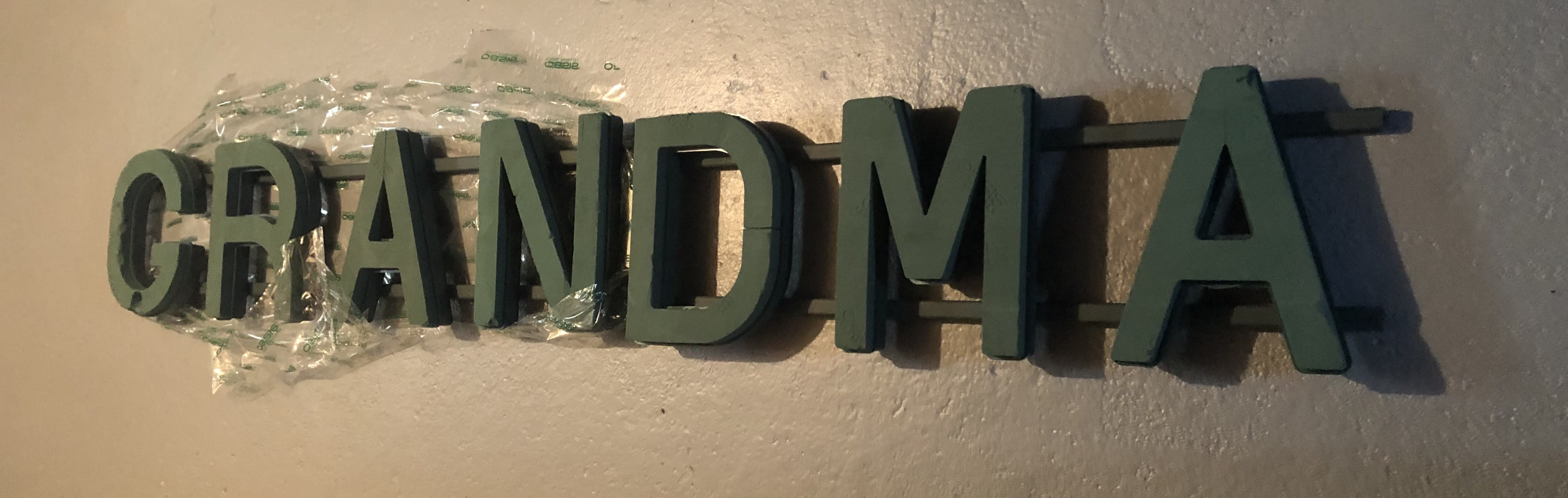 Grandma - This is our &quot;Grandma&quot; wording. It is not flowered yet. This is just the raw wording for your sympathy needs. It will be flowed with white button mums and accented on the last &quot;A&quot; and first letter &quot;G&quot; with your choice of colored spray roses and greenery.  The price listed is with the flowers included.  Inventory count: 2