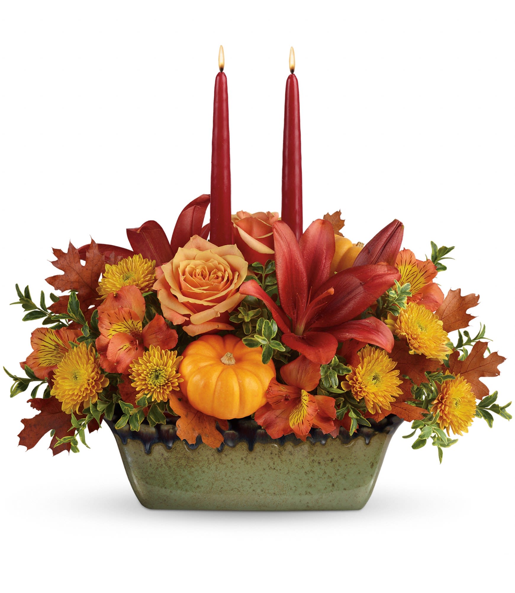 Country Oven Centerpiece - This fall favorite is two gifts in one, featuring a glorious autumnal bouquet hand-arranged in a gorgeous, hand-glazed stoneware serving dish.  Peach roses, rust-colored asiatic lilies, light orange alstroemeria, and bronze cushion spray chrysanthemums are arranged with oregonia, miniature orange pumpkins, transparent rust-colored oak leaves and two burgundy taper candles. Delivered in a Country Oven dish. Approximately 15 1/2&quot; W x 14&quot; H
