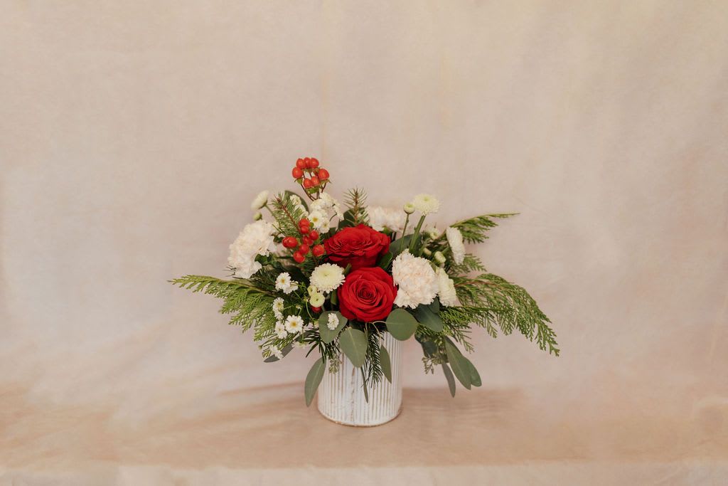 Peppermint stick - This bouquet is a great size for a dining room table or coffee table. It features winter greenery, red and white flowers.  Please read substitution policy. 