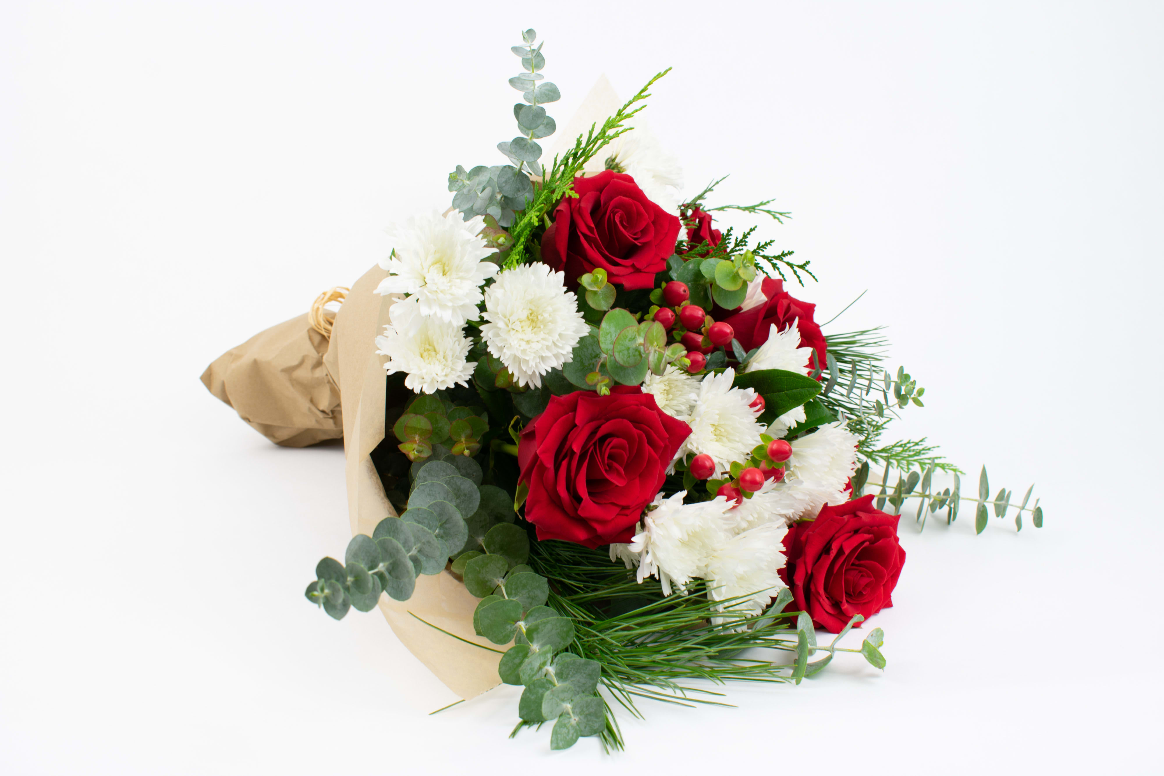 Winter Spirit - BEAUTIFUL CHRISTMAS FLOWER BOUQUET WITH RED ROSES AND BERRIES   Bright and joyful. This fresh Christmas flower bouquet is an absolute treat for friends, family and valued clients. Designed with festive red, white and green flowers and foliage, our bouquet is guaranteed to bring cheer and beauty into the home or office. One of our best-selling Christmas bouquets for 2021, this gorgeous bunch stars velvety red roses, long-lasting white chrysanthemums, shiny berries and fragrant pine.   Why not add a greeting card or quality handmade candle for an extra thoughtful touch to your Christmas gift?  Winter Spirit features: -Velvety red roses -Snowy white pom pom chrysanthemums -Shiny red hypericum berries -Fresh pine  -Fragrant cedar -Spiral eucalyptus -Brown kraft paper gift wrap  SIZE: The STANDARD flower arrangement is approximately 14” height and 12” width.  ALLERGY ADVICE: This design has low pollen and a low-moderate fragrance.    Ready to bring floral beauty into someone’s world with bright Christmas flower bouquet? Order this gift online now or give us a call on (415) 752-2060 if you have a question or special request. 