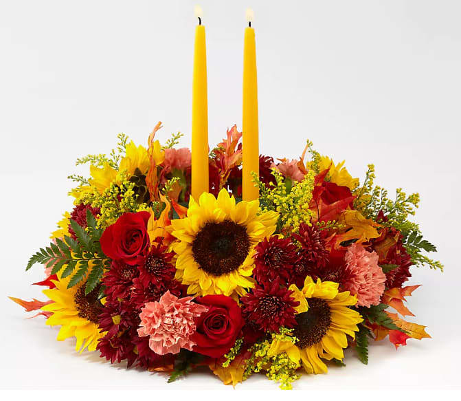 Giving Thanks Candle Centerpiece - Complete your tablescape with a centerpiece that is both fresh and charming. Golden yellow candles are surrounded by a mix of sunflowers, roses, and more.