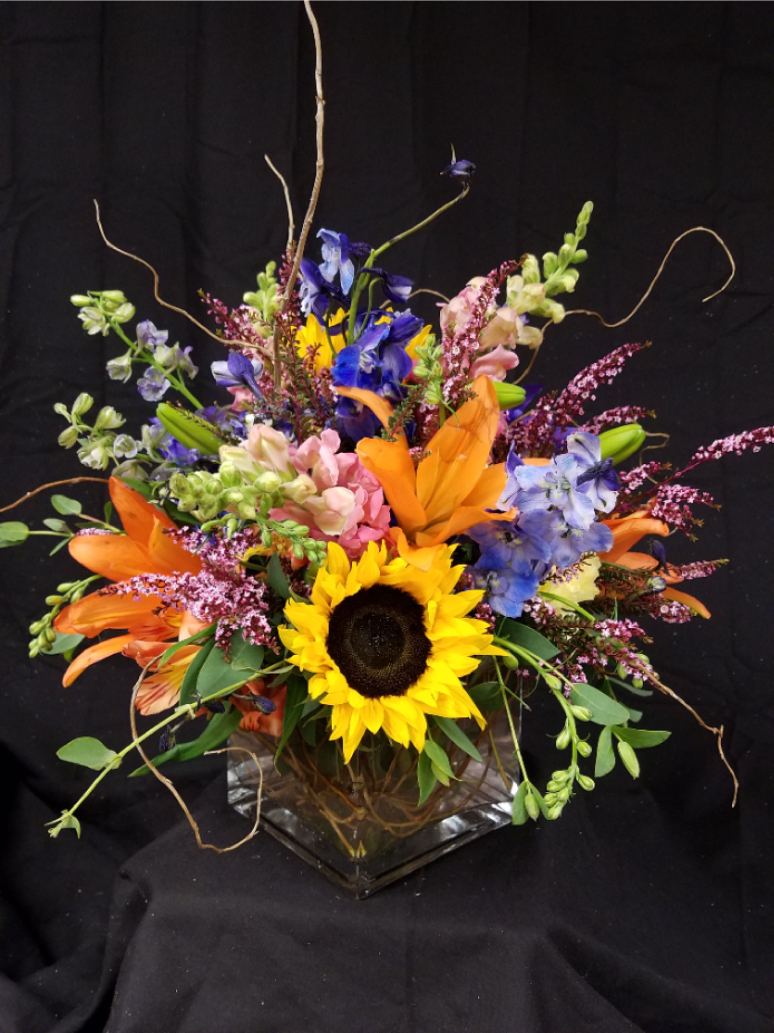 Color Explosion - Glass cube all around mixed floral arrangement. 