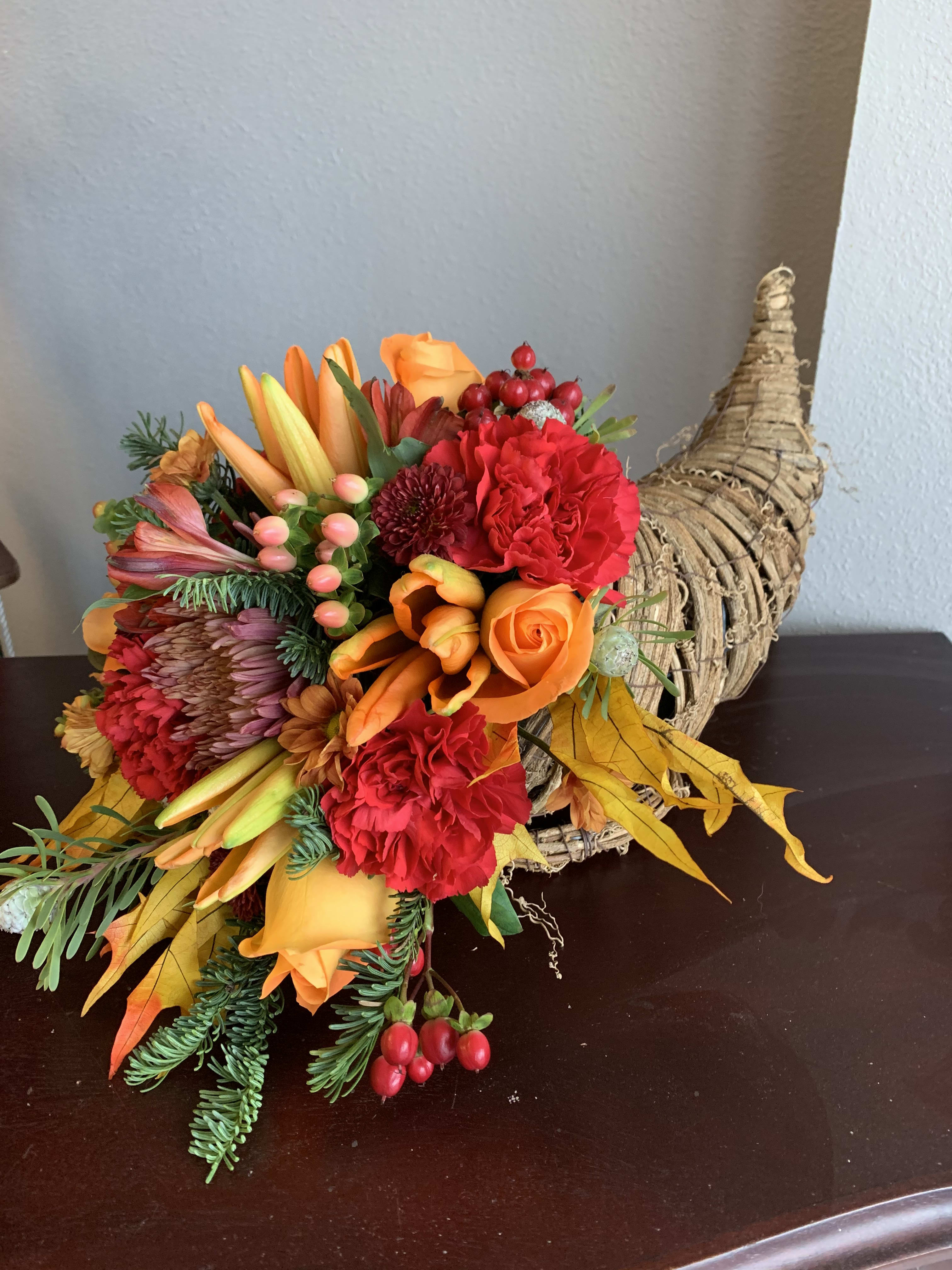 Cornucopia Center Piece - These cornucopias are sure to be a show stopper. We use the freshest fall flowers to make a beautiful arrangement. Everyone is sure to love the uniqueness of these beautiful flowers!