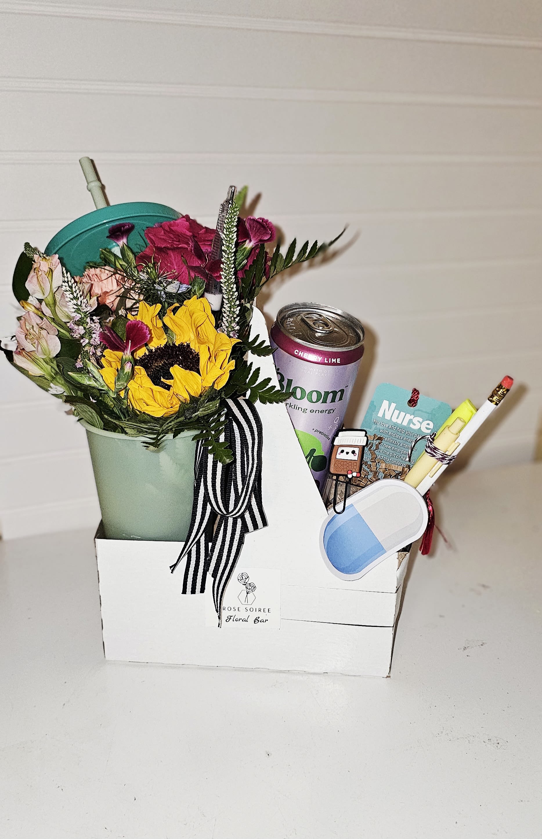 Floral &amp; Beverge Carrier arrangement  - Thanks a latte, nurse practitioner gift. The perfect little “pick-me-up” for any occasion.  Designer’s choice florals Paired with a canned latte or iced coffee , or energy drink. (drinks may vary)  Great for “Thanks a latte,” “I love you a latte,” or even a sweet treat!  Includes: Designer Choice mini bouquet in a  Keepsake tumbler with straw and lid Carrier Drink  