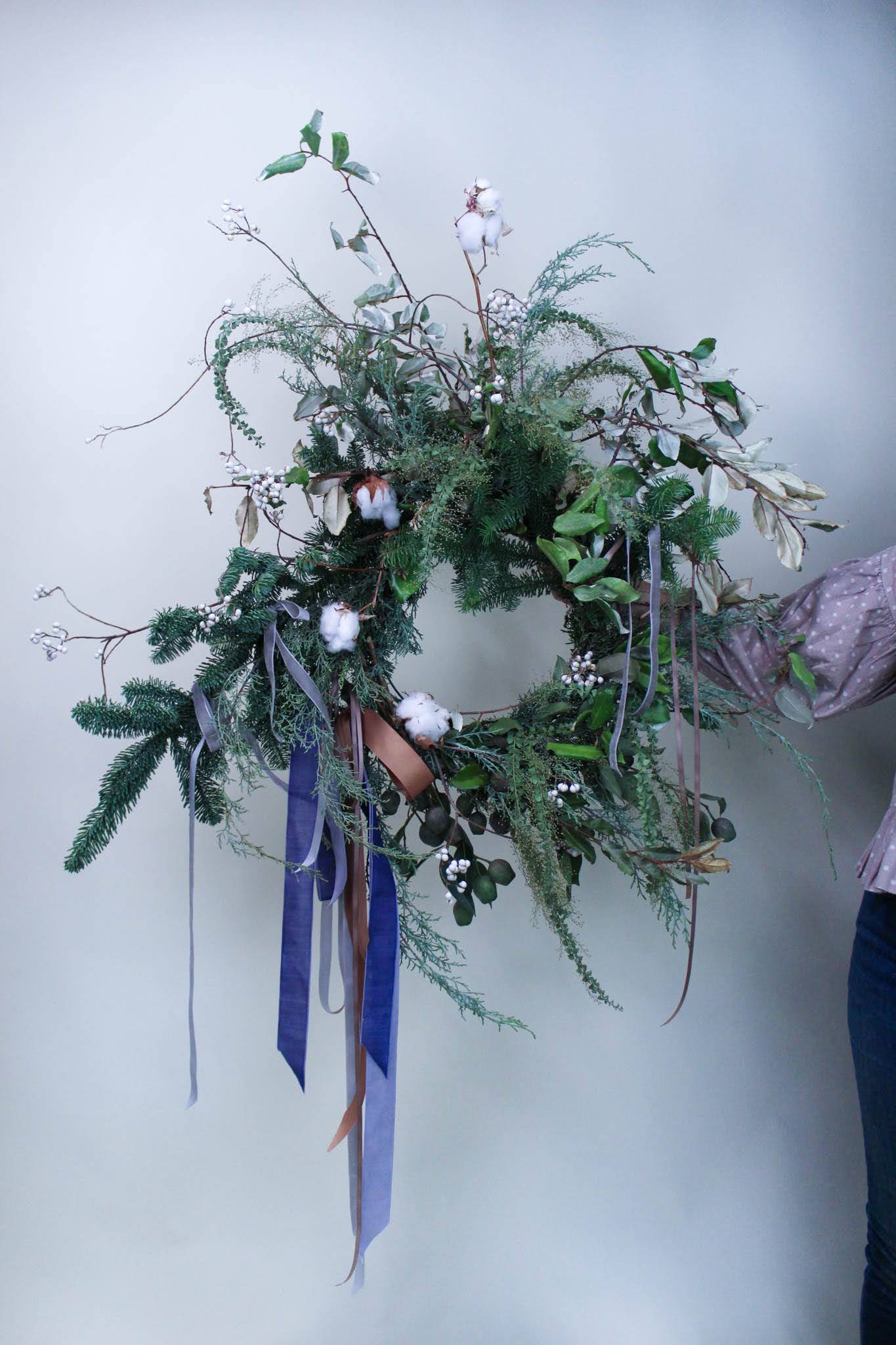 Evergreen Wall Wreath - A larger evergreen wreath perfect for above a mantle or on a wall.   *Images are a representation of our design style. Each arrangement is made to order and flower selection will vary due to product availability the week of your order.
