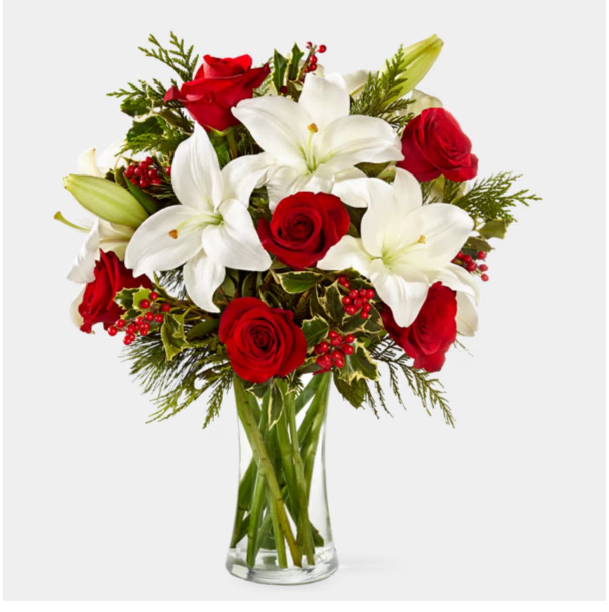 Sparkling Snowflake Bouquet - AVAILABLE STARTING 12/1  Celebrate the magic of the season with our Sparkling Snowflake Bouquet from Flower Synergy. This radiant holiday design features fragrant white oriental lilies paired with rich red roses, accented with festive holly berries and fresh Christmas greens for a crisp, wintry look. Arranged in a clear glass vase, it brings a perfect balance of elegance, color, and seasonal charm.  Ideal for Christmas gifting, winter celebrations, or brightening your home or office décor, the Sparkling Snowflake Bouquet adds a touch of holiday sparkle to any space. Available for delivery in Costa Mesa, Newport Beach, and surrounding Orange County areas. 