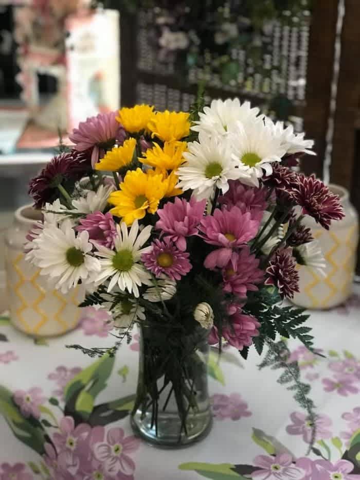 Miss Daisy - A mix of colorful daisies and premium greenery. 