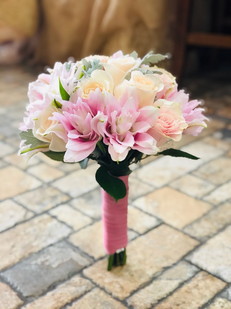 Blushing Bridal Bouquet  - This simple and elegant bridal bouquet is sure to make your big day memorable. Filled with soft pinks and whites - this assorted bouquet features roses and lush greenery. 