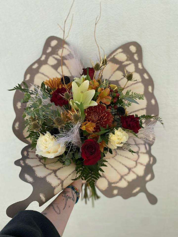 Butterfly Kisses - An assortment of red and white flowers wrapped in premium butterfly wing designed floral paper. Please not flowers may vary but we do our best to create a unique and beautiful bouquet. Vase not included. 