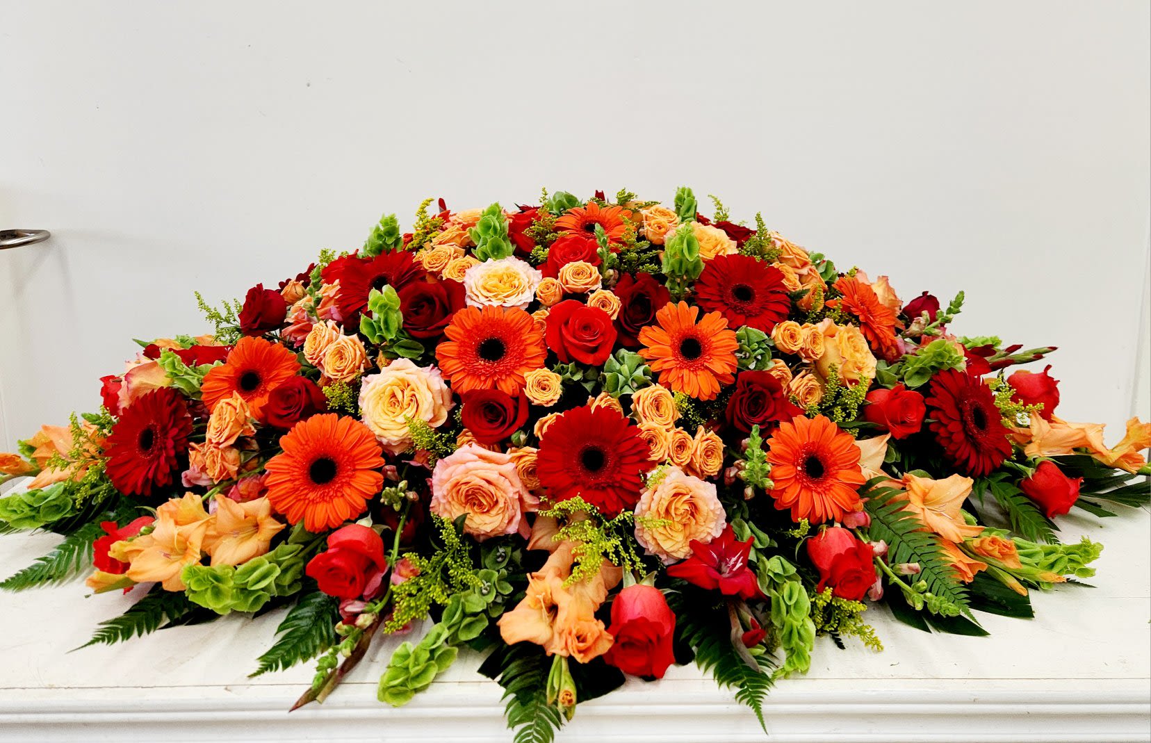 Colorful Remembrance Casket Spray - Celebrate a vibrant life well lived with the Colorful Remembrance Casket Spray. This elegant arrangement brings together bright, joyful blooms that reflect a spirit full of kindness and unforgettable moments. Perfect for honoring a loved one whose warmth and generosity will be cherished forever. AS SHOWN: Premium: 52&quot; L X 30&quot; D