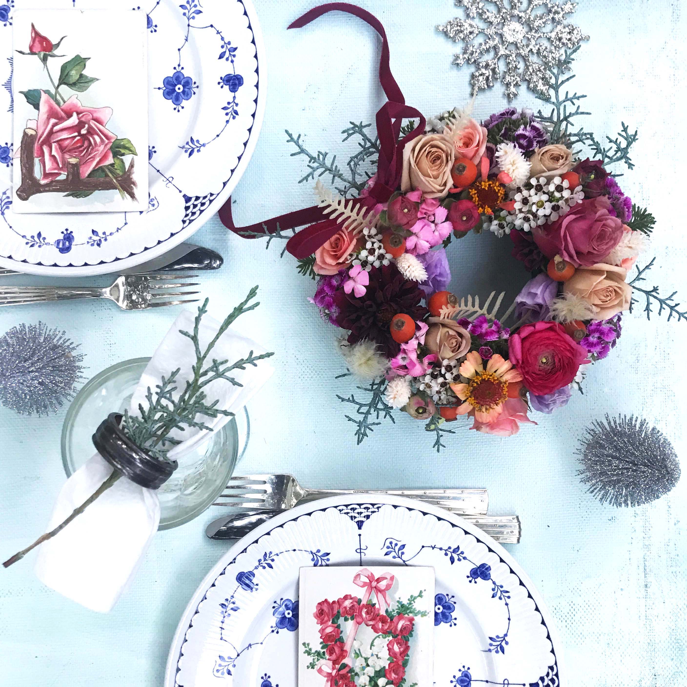 Hannah wreath - A beautiful small and very pretty wreath for your dinner table, made of fresh flowers in pretty warm colors, to give that elegant light and shine to the festive season tablescape - or hang on the door. A beautiful and personal, fresh and unique floral gift with deep red velour ribbon. Measuring appx 7&quot;. Place one or more on your Thanksgiving or Christmas table and let the light shine on your dinner party. Upgrade to a size 8,5 &quot; for a bigger version.