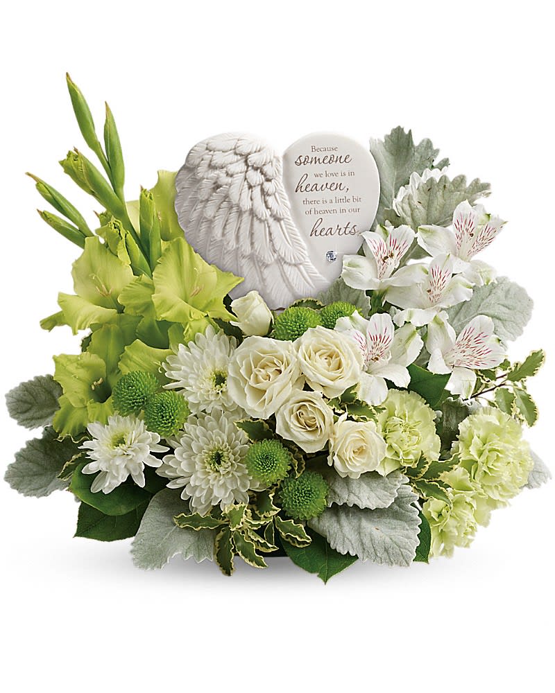 Hearts In Heaven Bouquet - A heartfelt expression of your sympathy this majestic mix of white roses will rejuvenate the spirit. Nestled among the blooms is a graceful angel's wing keepsake etched with an encouraging message they'll cherish forever. Message on sculpt reads: &quot;Because someone we love is in heaven there is a little bit of heaven in our hearts.&quot; White spray roses white alstroemeria green gladioli green carnations green button spray chrysanthemums and white cushion spray chrysanthemums are accented with dusty miller pitta negra and lemon leaf. Delivered with a Heaven's Heart keepsake.