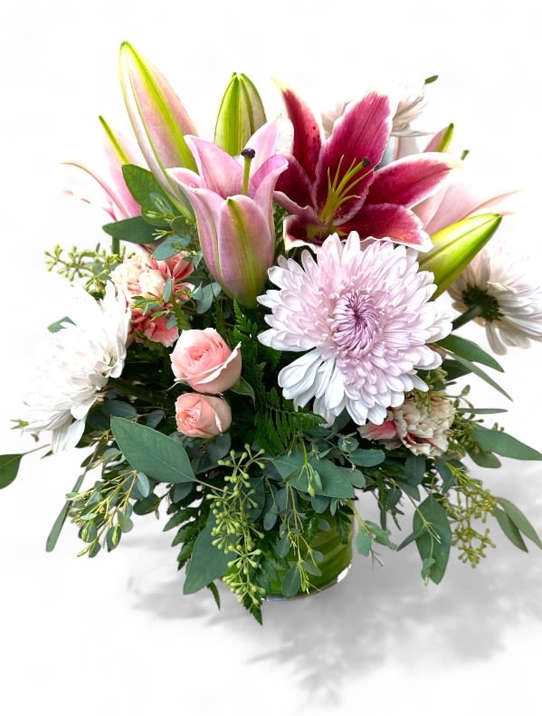 Elegant Blooms Vased Arrangement - The Elegant Blooms Vased Arrangement features soft pink lilies, cheerful mums, and delicate carnations that harmonize beautifully to create a serene and inviting arrangement. Interspersed with fragrant eucalyptus, the bouquet adds a touch of greenery and texture, enhancing its overall appeal. 