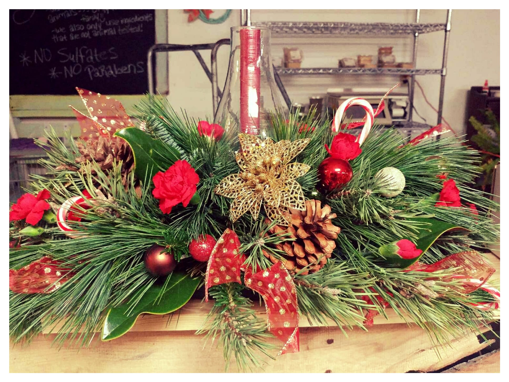  Christmas Centerpiece - Single candle in a centerpiece accompanied by beautiful festive greens and filler