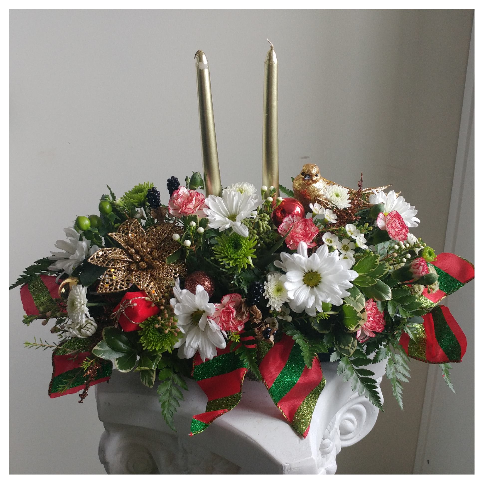 Winter Green Centerpiece - Double candlestick centerpiece filled with beautiful holiday colors and flowers, and bright holiday ribbon- Flowers and filler may vary *** Order at least a day in advance to delivery date ***