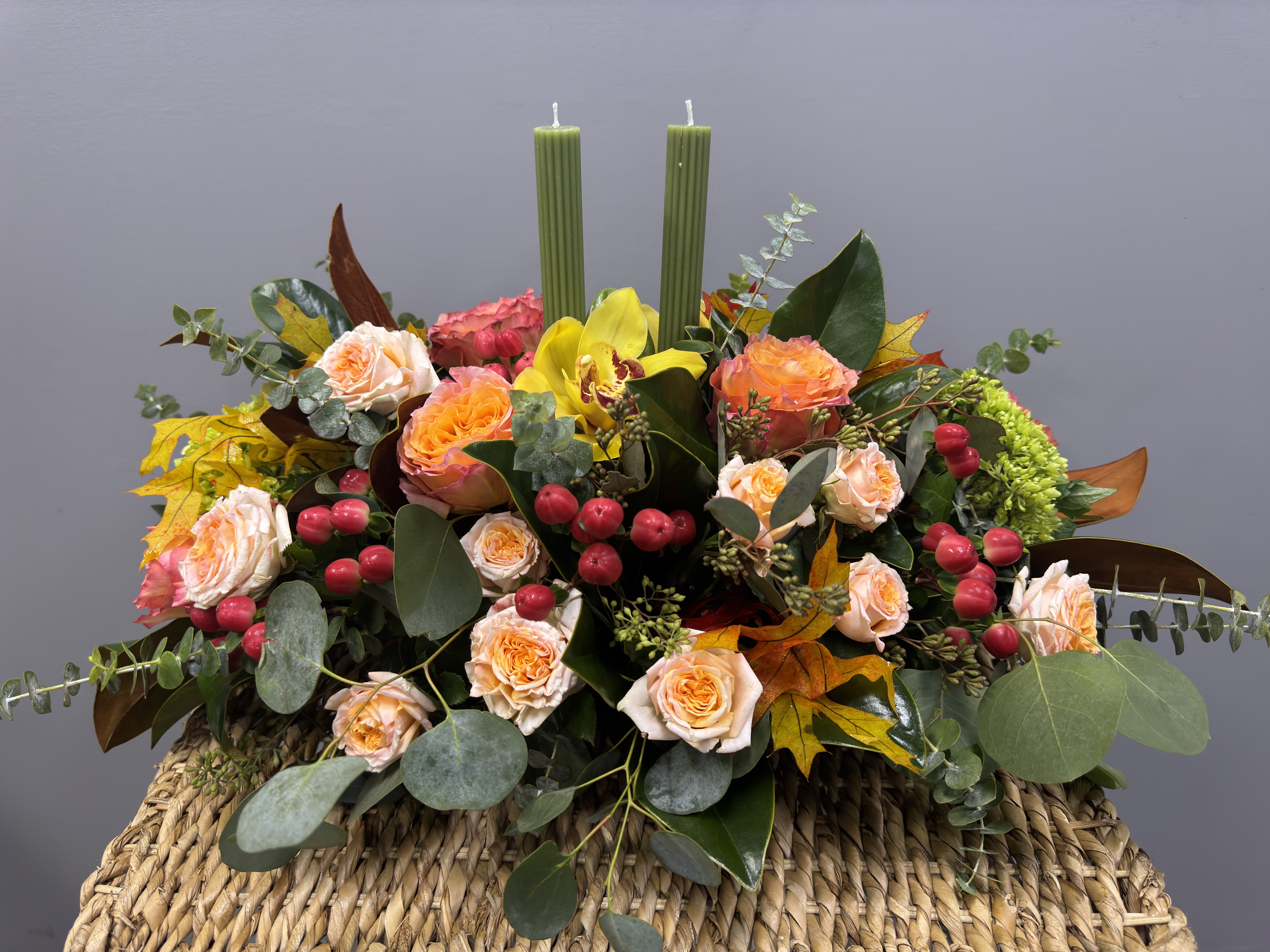 Thanksgiving Blooms - This long and low centerpiece features elegant olive-green candles paired with seasonal flowers, making it the perfect addition to Thanksgiving holiday table.