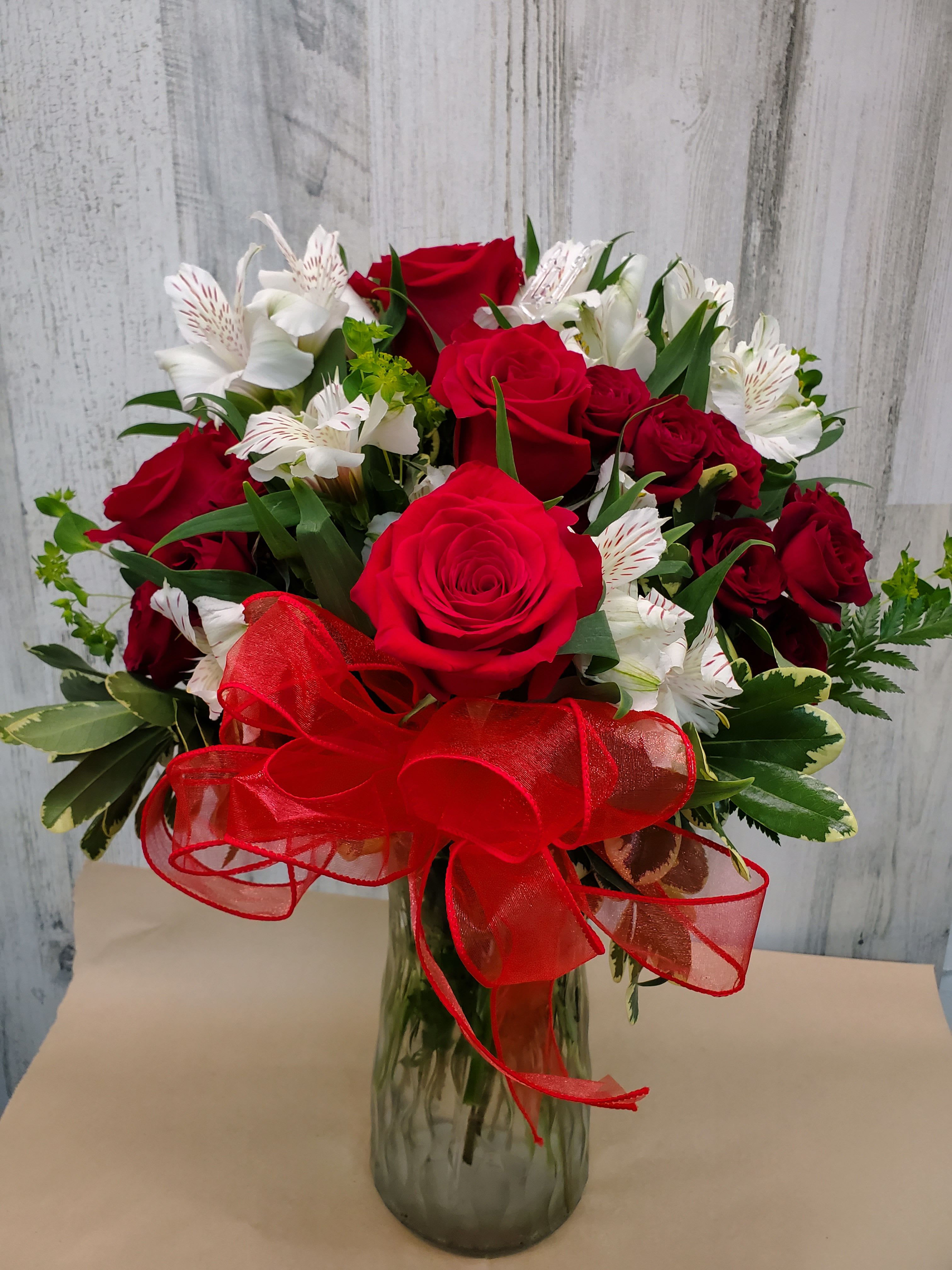 Serena - Endless roses, endless romance! Make a statement with our stunning bouquet of red roses with snowy white blossoms, delivered in a glass hurricane vase that will forever remind her of your love.         