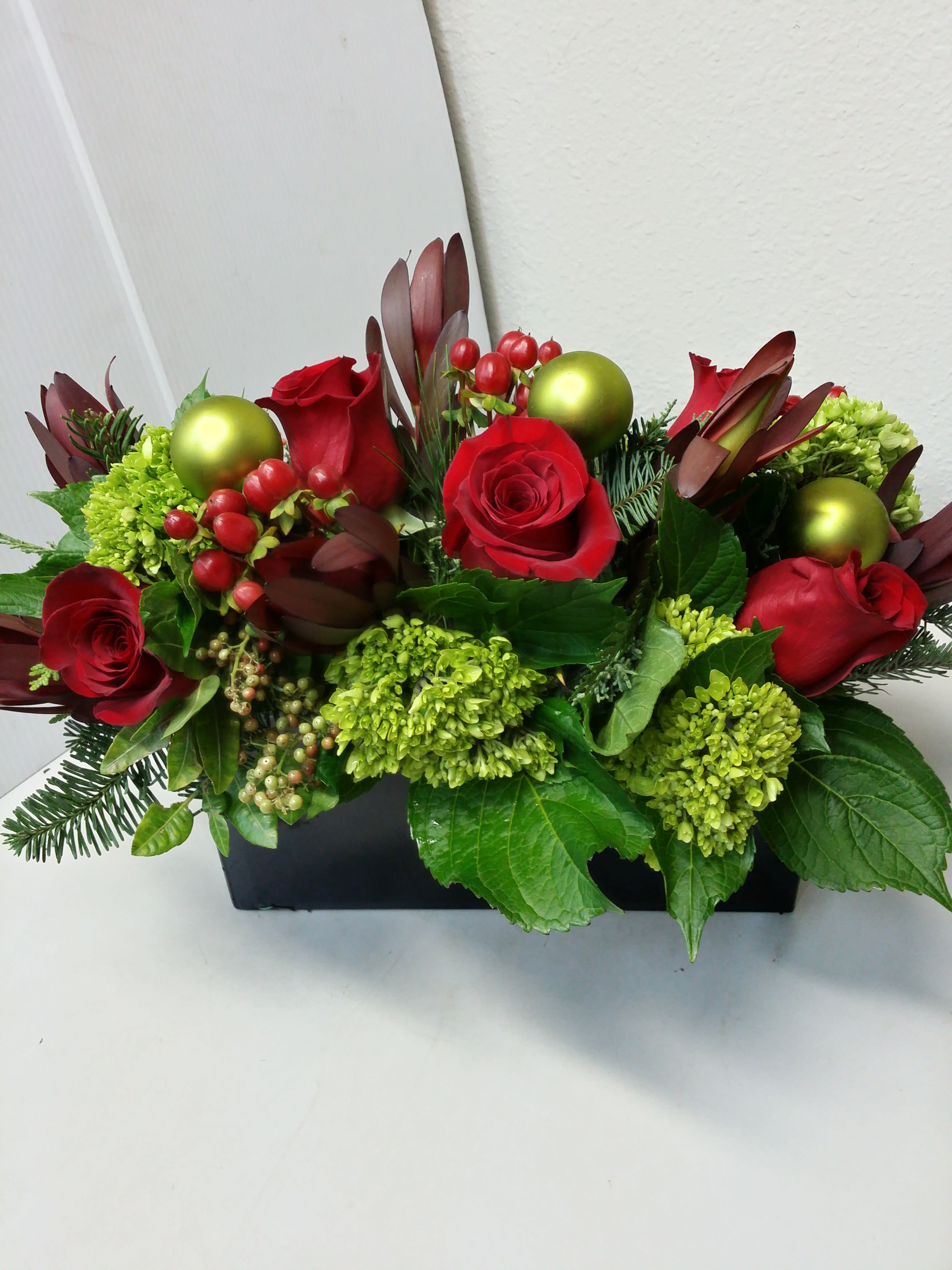 Hohoho! - a rectangle birch box (not pictured), perfect for the holiday table, low enough to talk over, but perfect in size for a table seating 8. Filled with seasonal winter greenery, pine cones, ornaments, berries, and red roses and hydrangea.