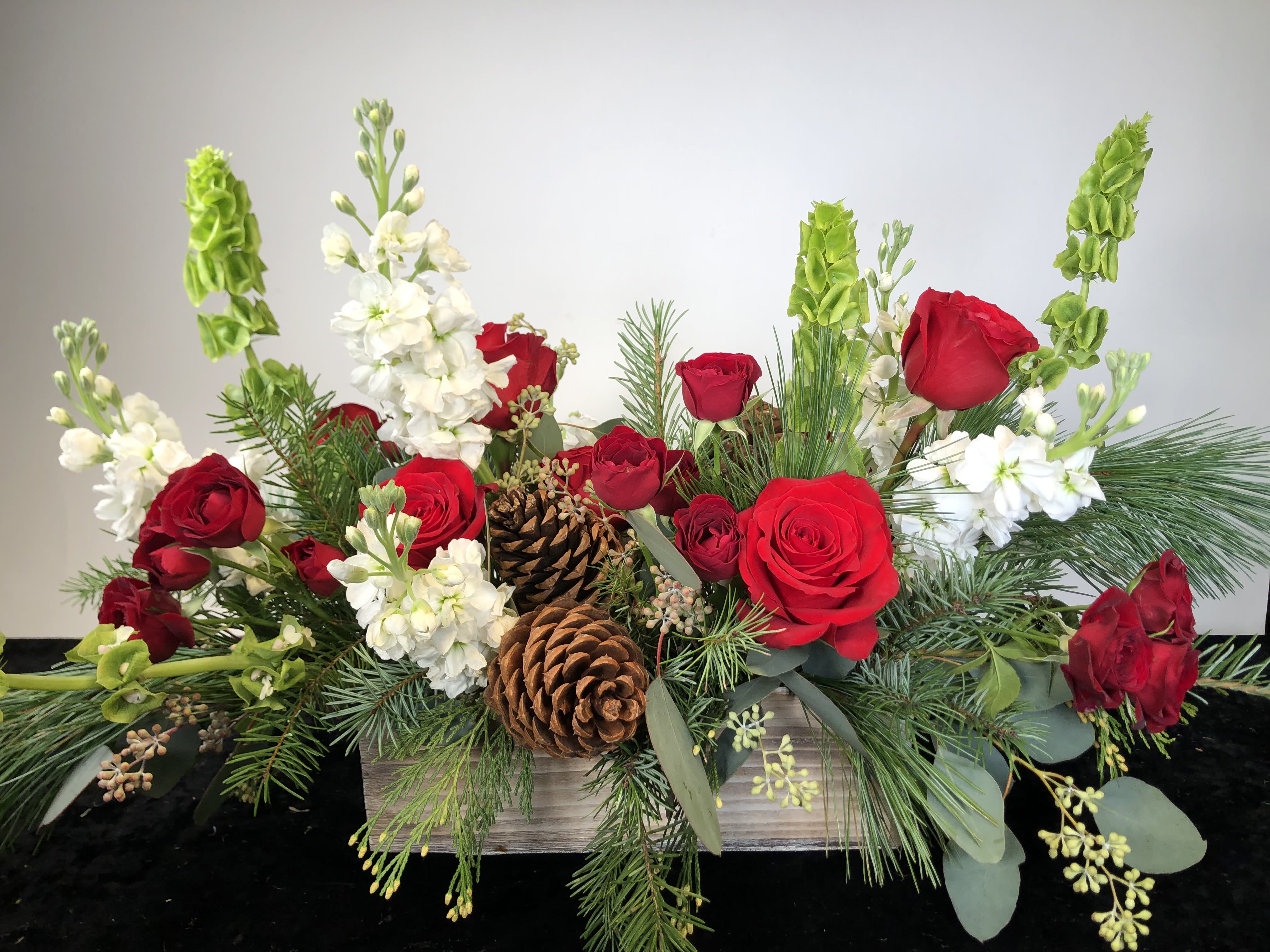 Winter Solstice  - A lovely long and low arrangement to adorn your holiday table.  We can add more holiday elements if requested, or can leave it as a winter arrangement.  