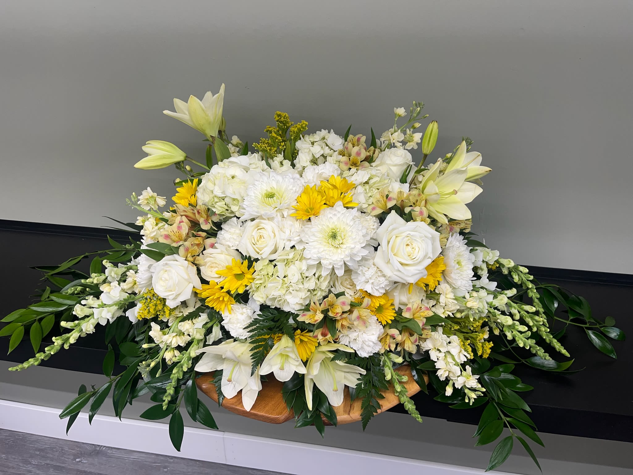 Golden Glow Casket Spray  - Radiant yellow and soft white blooms blend in a graceful display of warmth and remembrance. Golden Glow asked Spray symbolizes hope, peace, and the everlasting light of cherished memories.