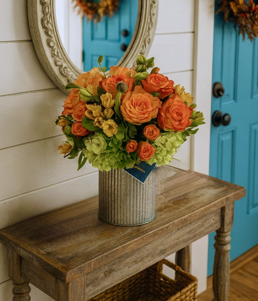 Cider and Spice Seasonal Fall Arrangement - Cider &amp; Spice Floral Arrangement  Welcome the cozy charm of autumn into your home with our Cider &amp; Spice floral arrangement, a seasonal favorite designed to warm hearts and brighten spaces. Bursting with vibrant orange roses, cheerful spray roses, golden alstroemeria, and lush green hydrangeas, this handcrafted bouquet captures the essence of fall in every petal.  Styled in a rustic farmhouse vase, Cider &amp; Spice makes the perfect centerpiece for an entry table, dining room, or coffee table. Its rich autumn hues bring the same comfort as a warm cup of cider on a crisp day, making it ideal for fall, or as a thoughtful “just because” gift.  Whether you’re sending love to family and friends or decorating your own home, the Cider &amp; Spice arrangement is a beautiful bouquet ensures your space feels inviting, festive, and full of fall spirit.   