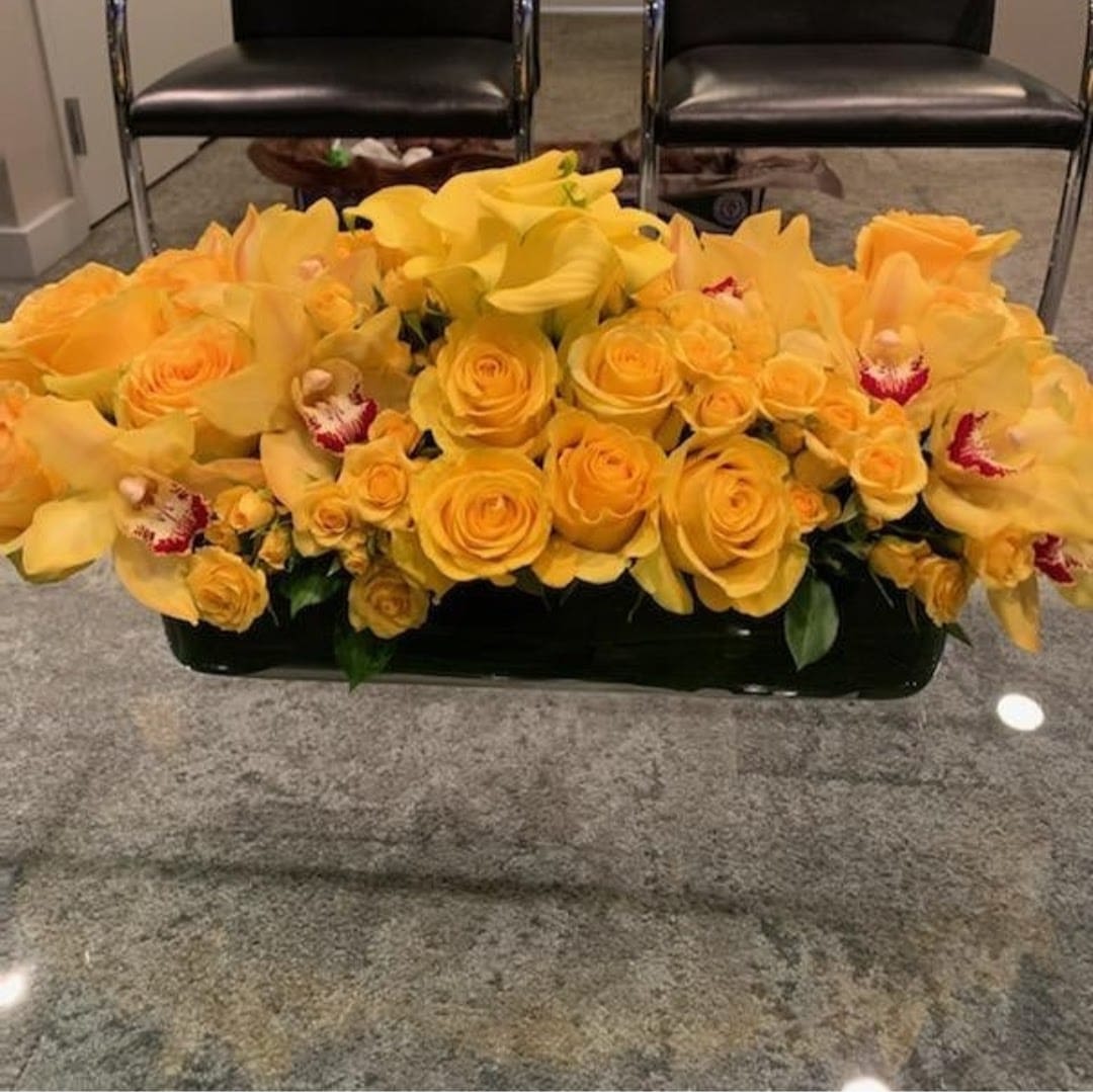 Yellow Stars - This stunning arrangement is made up of yellow cymbidium orchids, yellow roses, yellow calla lilies, and yellow spray roses.