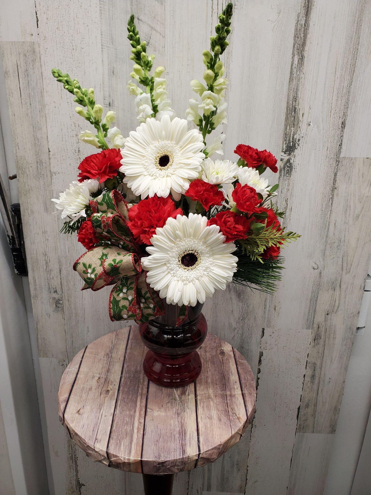 O Holy Night  - This Bright arrangement Will bring a thrill of Christmas time to any home.  Red Vase filled with fresh Christmas greens and assortment of red and white flowers.
