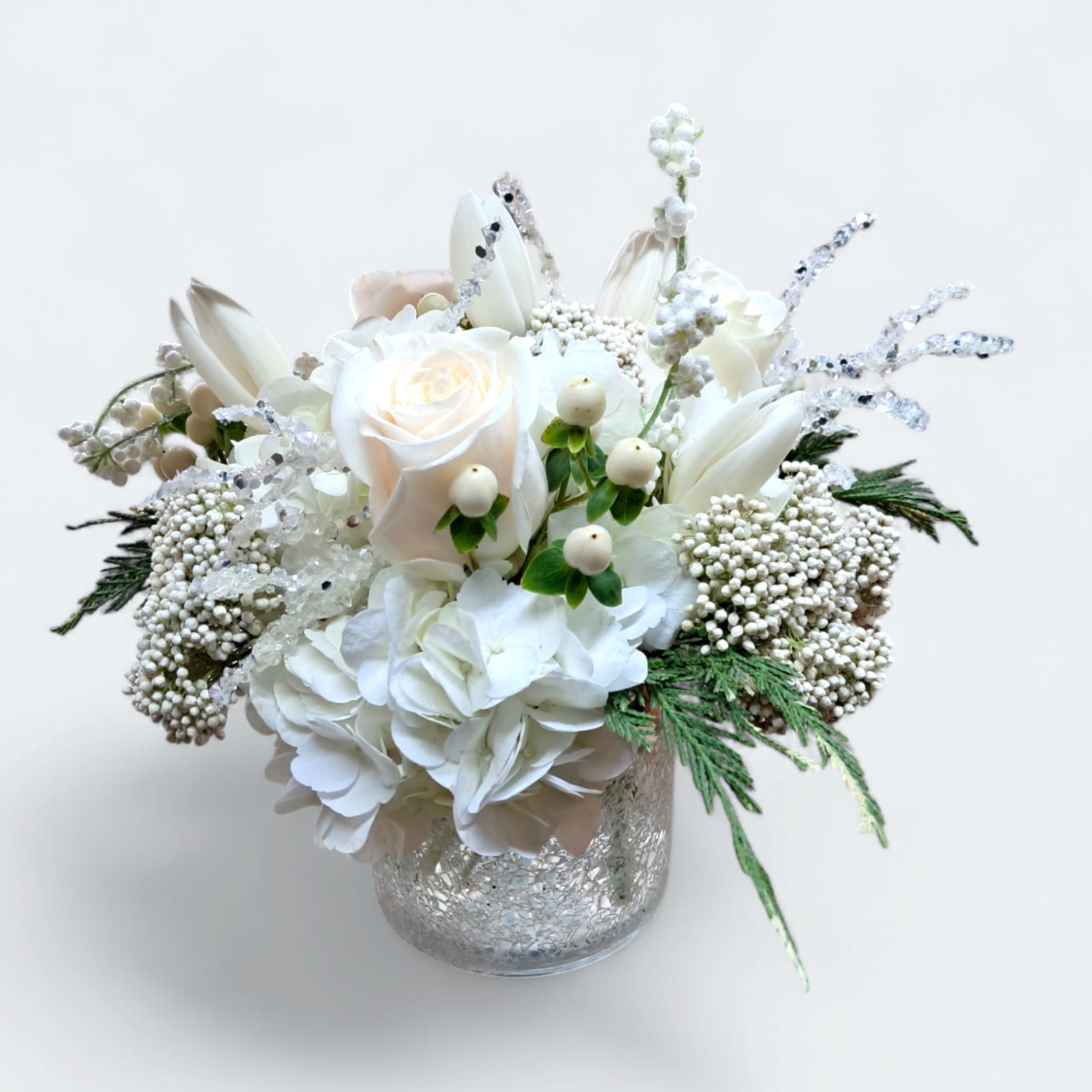White Like Snow - This magnificent arrangement has roses, tulips, hypericums, rice flower, hydrangeas, and decorative white stems. 