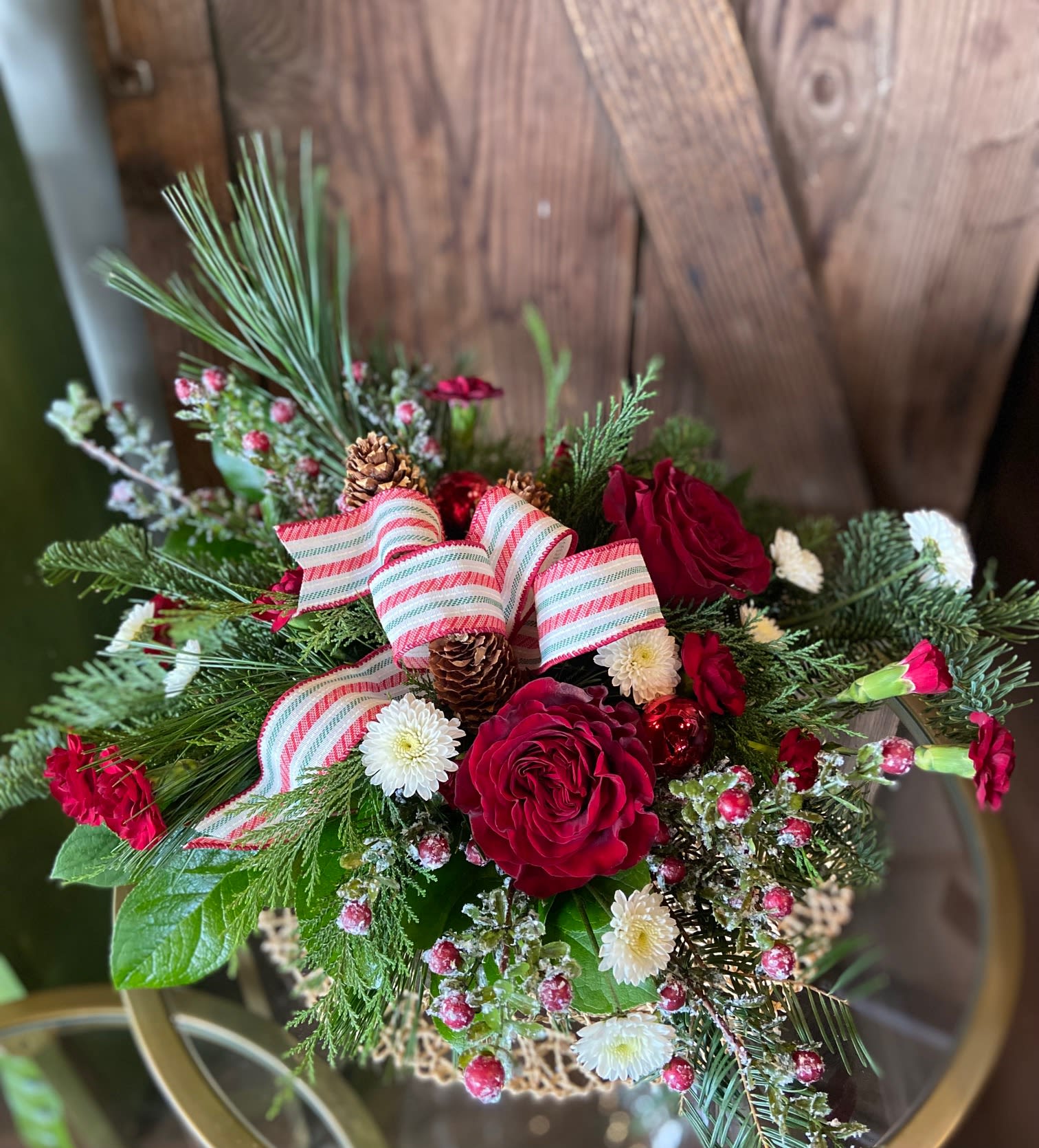 Winter Wonderful - Low and classic wintery arrangement with long lasting evergreens, artificial winter berries and a tasteful bow in a winter feeling keepsake container. *flowers and ribbon may vary.