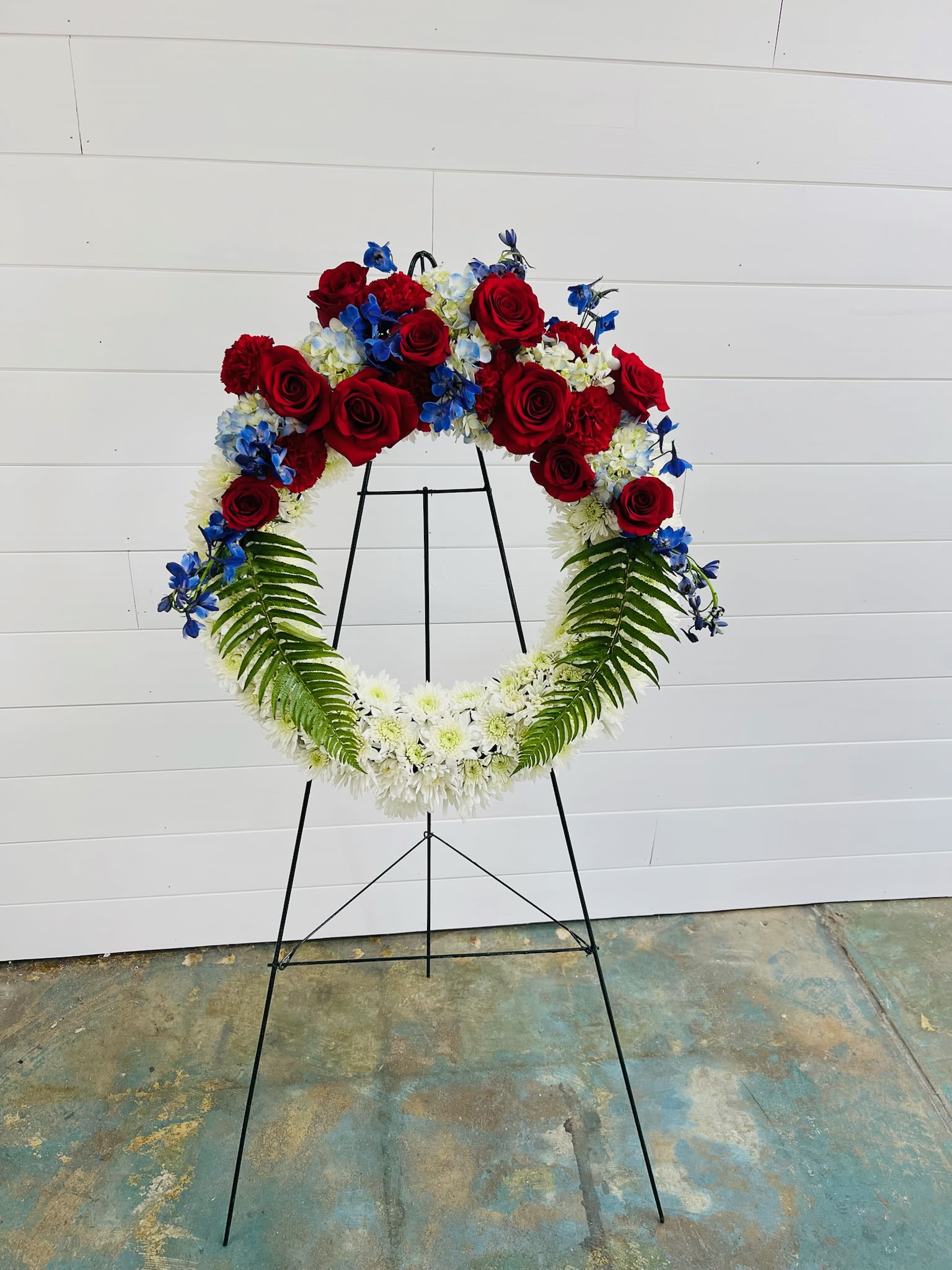 Patriotic Floral Wreath - A respectful tribute featuring fresh blooms in classic red, white, and blue, the Patriotic Floral Wreath honors the memory of those who served and sacrificed.