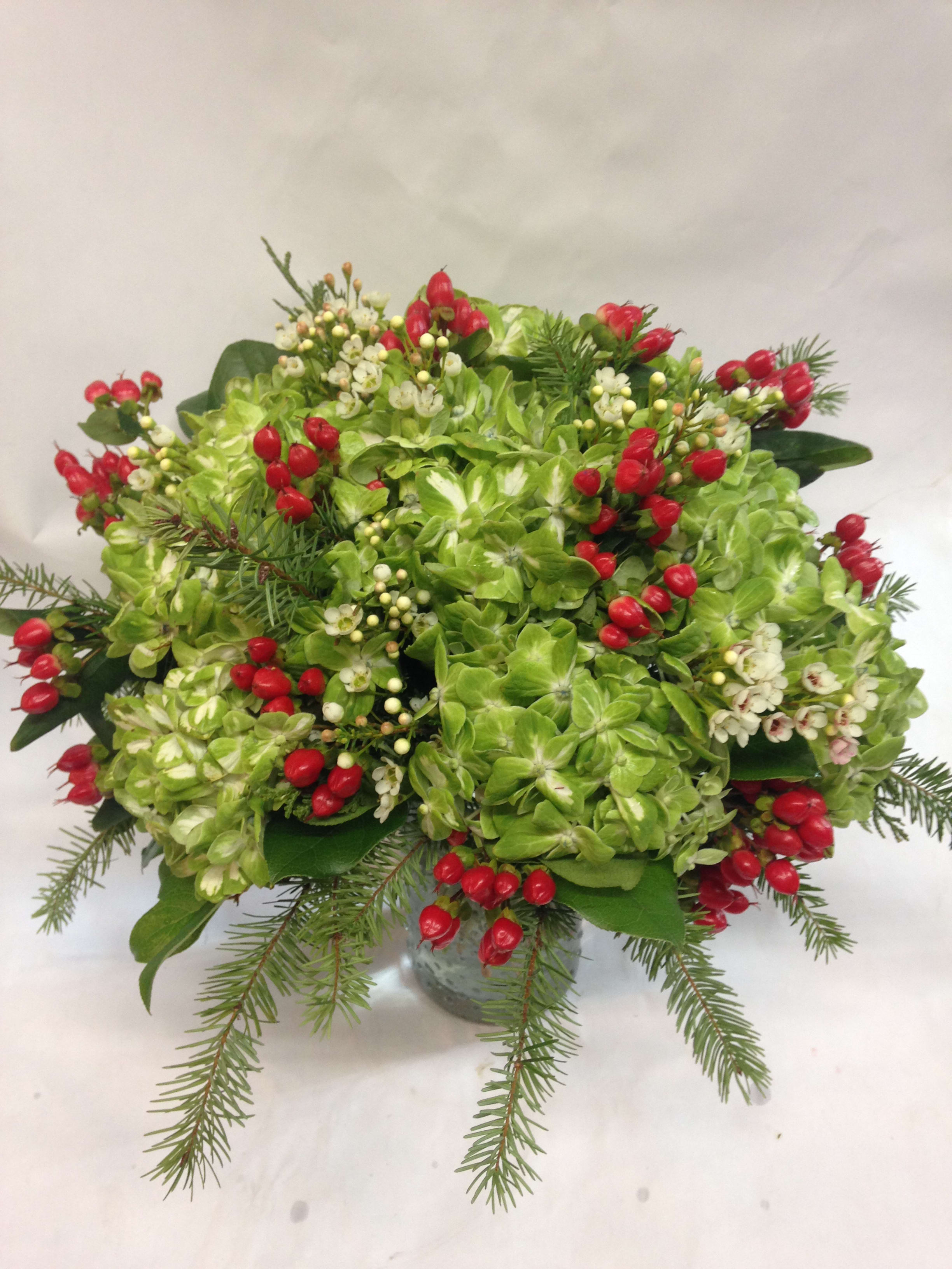 Green Hydrangea Holiday Cheer - A festive vase arrangement featuring green hydrangea, hypericum berries, and pine branches. Featured arrangement:125.00 (Regular Price)