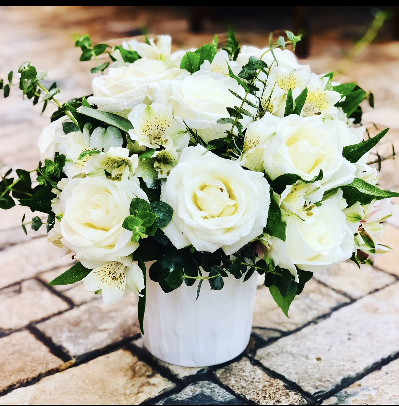 Heaven’s light  - Elegant and serene, this white vase arrangement offers a heartfelt expression of sympathy and remembrance. A graceful gathering of pure white roses, lilies, carnations, and delicate snapdragons rests in a classic white container. 