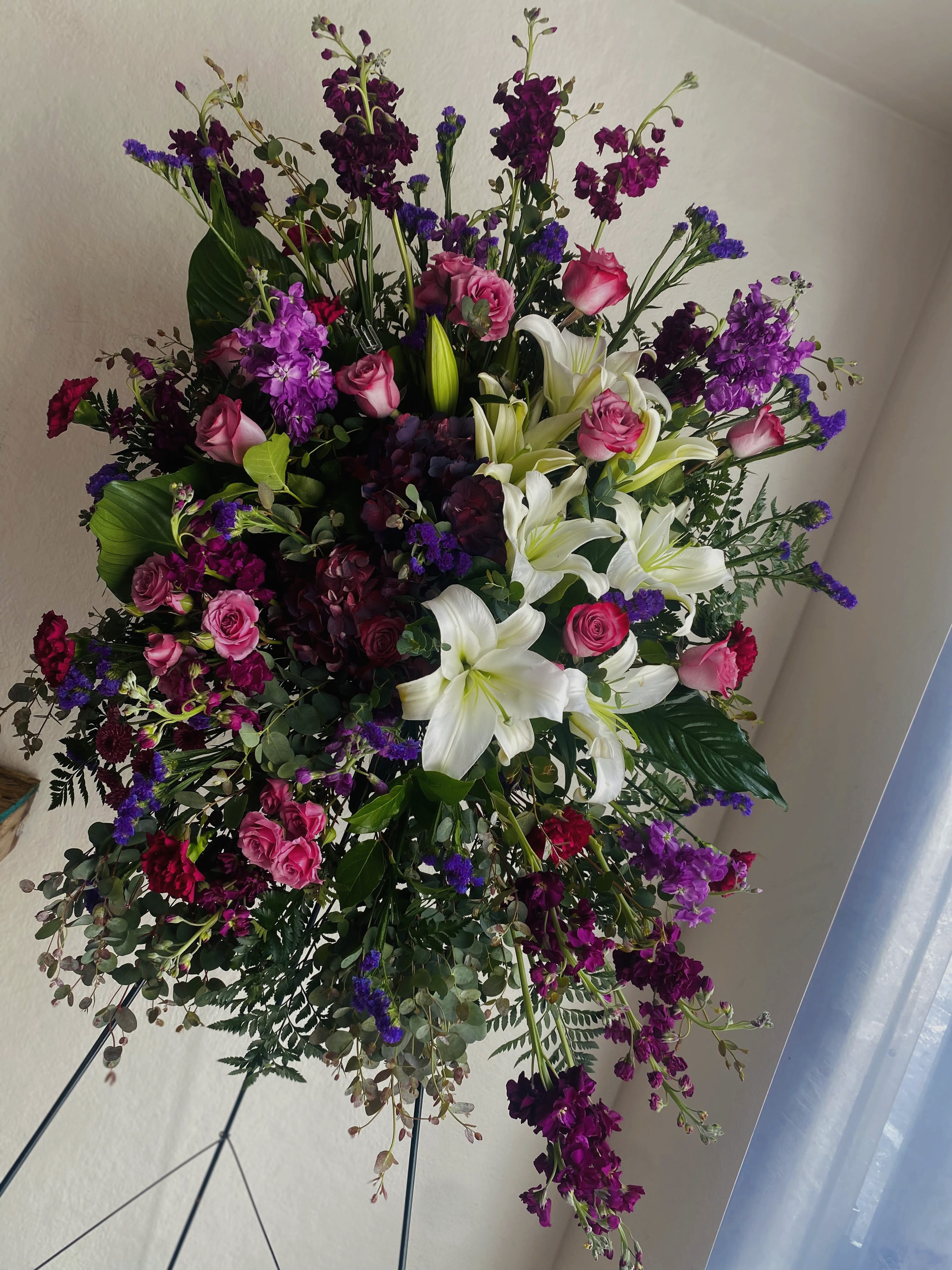 Blush&amp; Lavender Remembrance  - Blush and Lavender Remembrance” is a tender standing spray that honors a cherished life with soft sophistication. The delicate blush blooms symbolize love and gratitude, while the calming lavender flowers convey peace, serenity, and devotion. Thoughtfully arranged with gentle greenery, this spray offers a heartfelt farewell, wrapping your loved one in warmth, beauty, and a graceful tribute that reflects the depth of your affection and memories.”