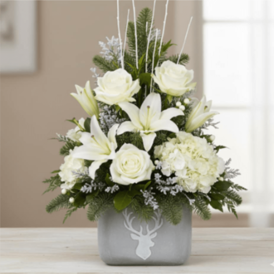 Stag's Winter White - That is a gorgeous, sophisticated winter arrangement in a unique container! The deer motif and clean white flowers give it a modern, yet festive, feel.The bouquet is beautifully presented in a matte silver or gray ceramic cube vase featuring a stylized white stag head silhouette. This unique keepsake container makes it a perfect, memorable gift or a stylish addition to modern holiday decor.