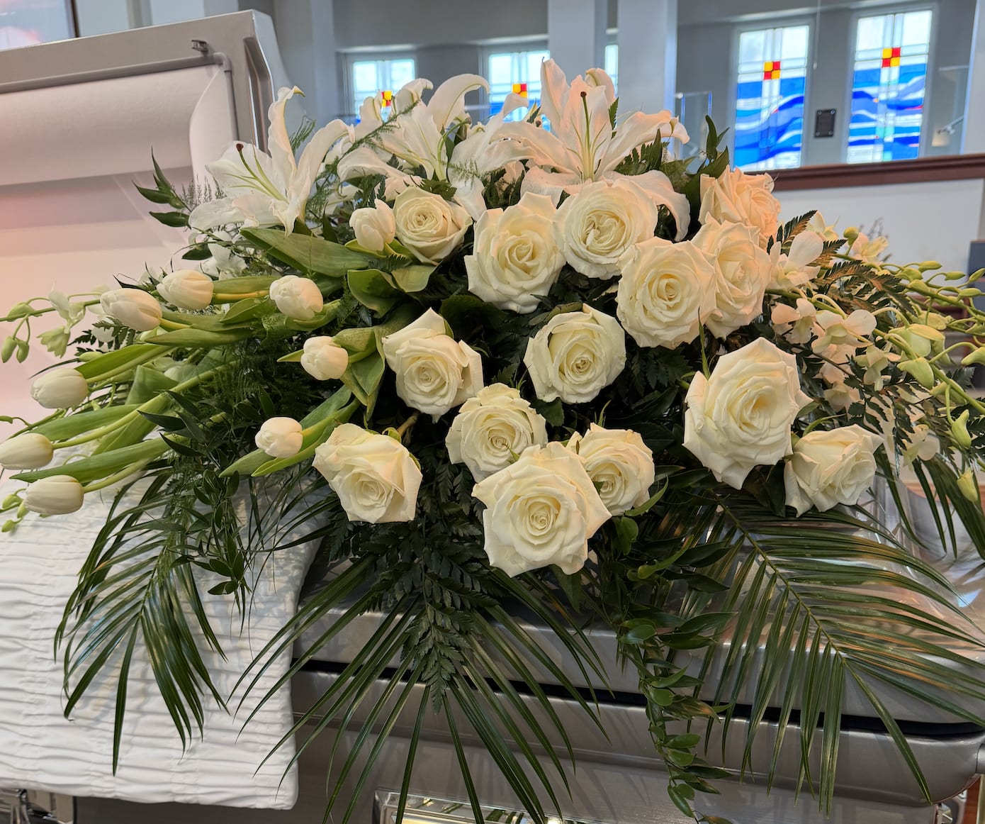 Sympathy Collection - Full Casket - Our Sympathy Collection includes this casket spray with a color choice of white, red, yellow, purple or pink. Our design will include Orchids and other feature white flowers that may included Calla Lilies, Daisies, Hydrangea (Mini and Large), Asters, Mums, Roses, Snapdragons. honor the loved one who meant so much to you, your family and your community. 