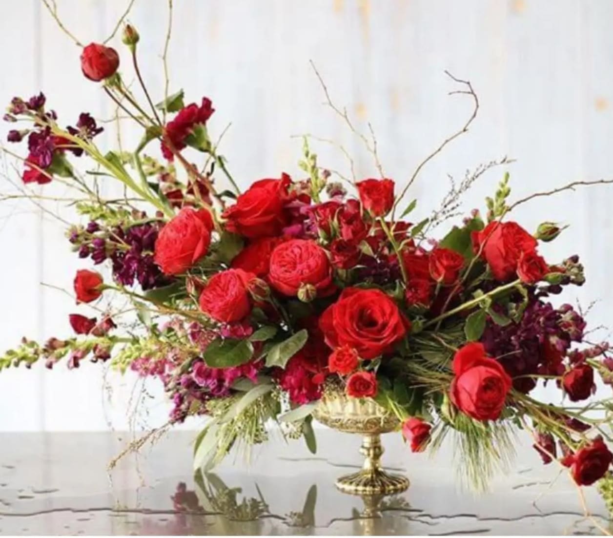 At Last - This show stopper is beautiful arranged in a vintage vessel, highlighting some of the seasons most lushes blooms in vivid shades of red! 