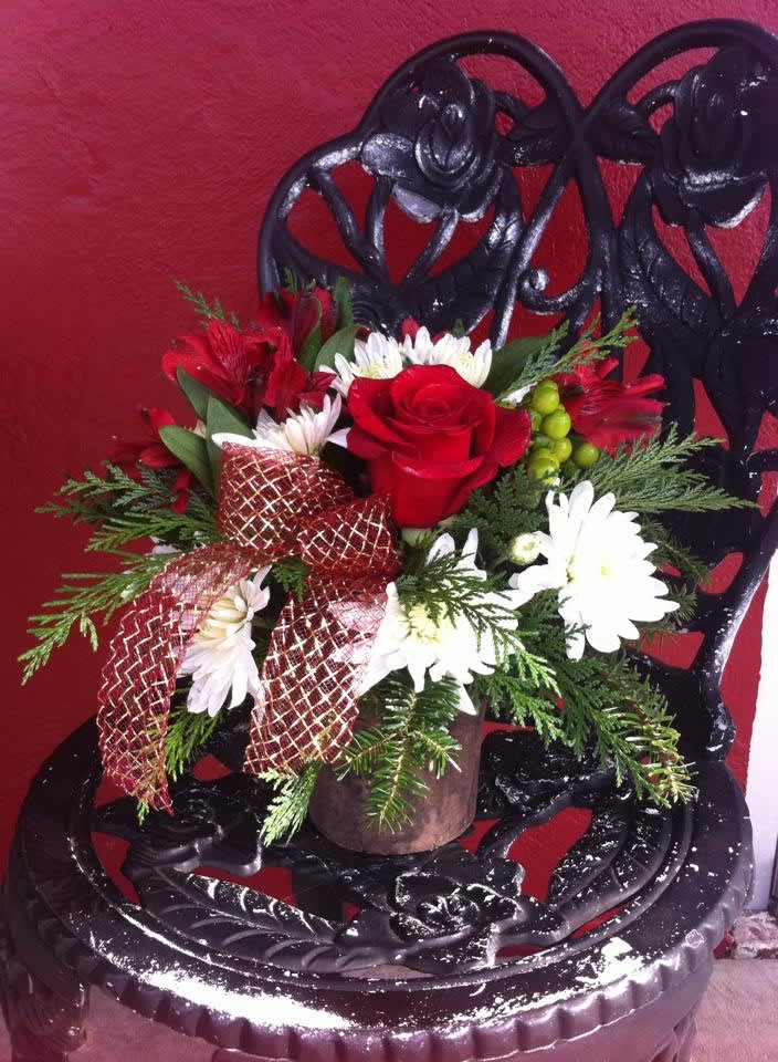 Southern Charm - Christmas Edition (candle &amp; flowers) - Our best selling product- with a Christmas theme! Fresh fragrant blooms are arranged atop a pottery jar with a hand poured soy wax candle scented in fragrances you will recognize from the south! Acadia, Evangeline, Zydeco Amber, &amp; Bayou Blossom are just a few of these delectable fragrances. (All designs are arranged as similar as possible. We promise to keep the same color, style, and overall theme with what Mother Nature generously blesses us with)