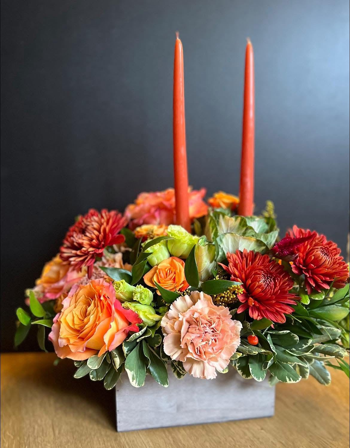 The classic centerpiece  - Two tall taper candles rise from the center of this autumn flower arrangement - adding height, warmth, and a soft glow—perfect for that Thanksgiving gatherings.