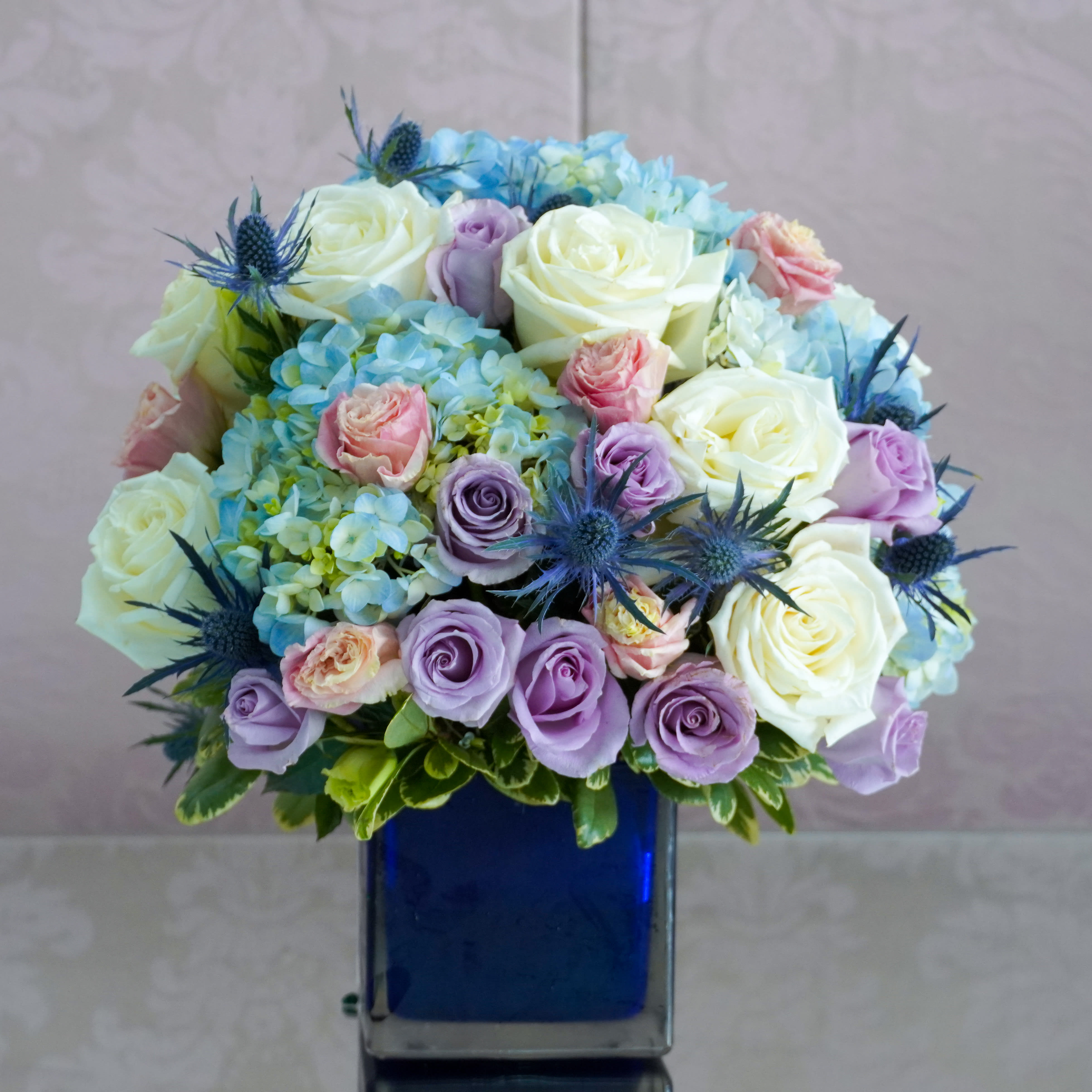 Beautiful in Blue  - Brighten the home with the peace and beauty of a bright blue sky. This beautiful bouquet with pure white flowers in a gorgeous blue glass vase.