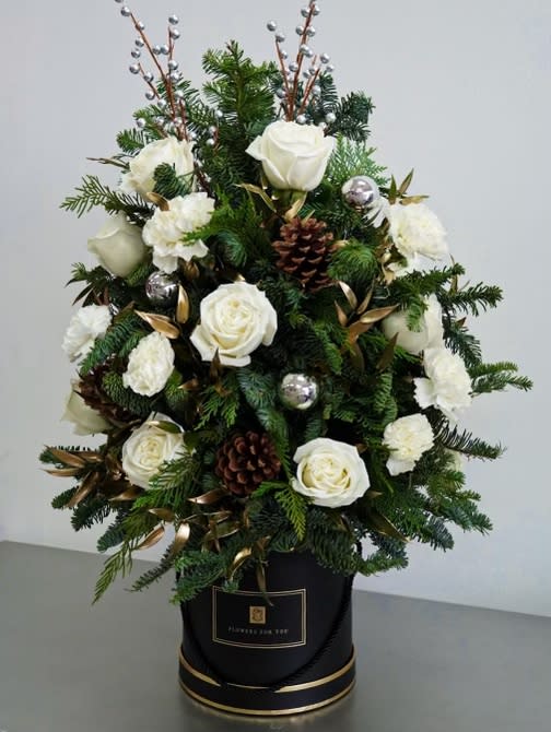 Christmas Tree by Atlanta's Finest Flowers  - Decorate your own home or send a loved one a generous helping of holiday cheer with this stunning Christmas floral arrangement. Shaped like a Christmas tree, it's comprised of white Roses , white Carnations , and Christmas greenery   Size 24&quot; H 16 &quot; W