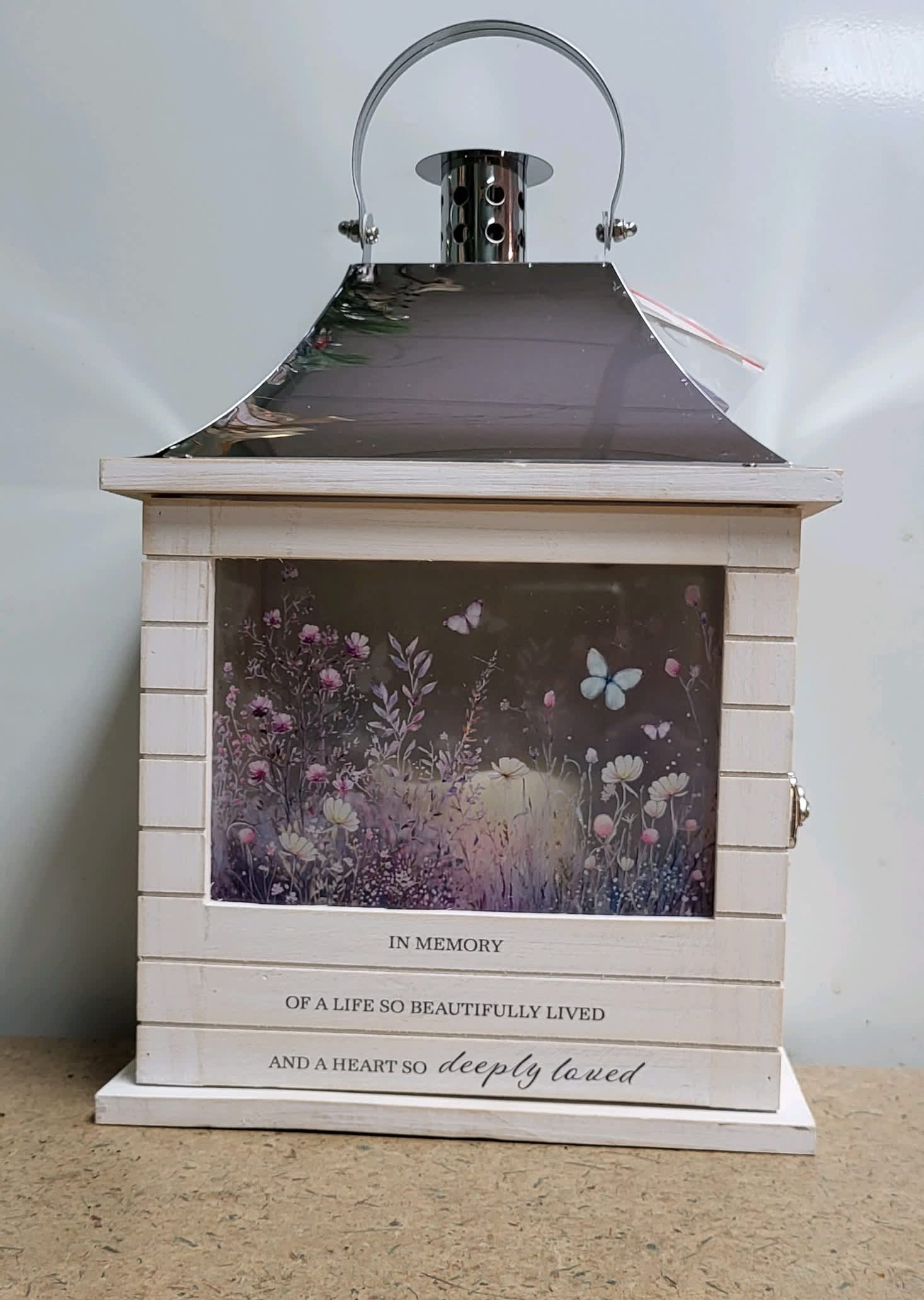 SO DEEPLY LOVED Whitewash Lantern - This new rectangular style lantern is 12 1/2"H x  8 3/4"W x 5 1/4 D and is delivered similar to picture with coordinating bow and enclosure card.  The lantern contains a flameless LED candle and is made of quality wood with a stainless steel finish top.  There is full color print on all sides and the wooden base displays "In memory of a life so beautifully lived and a heart so deeply loved."  Both beautiful and unique, this lantern is suitable to indoor use.