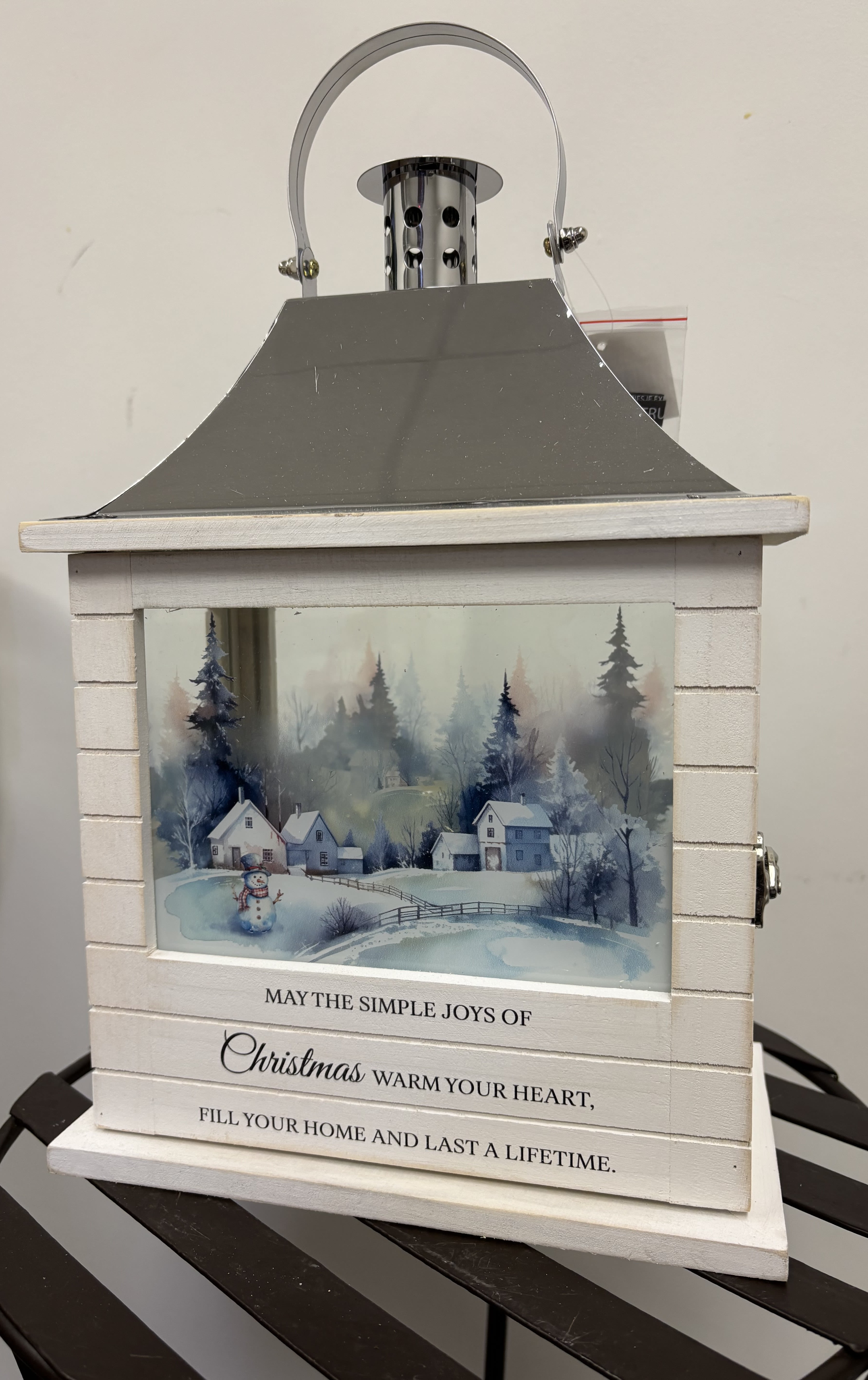 Joys of Christmas Lantern - This new rectangular style lantern is 12 1/2"H x 8 3/4"W x 5 1/4 D and is delivered similar to picture with coordinating bow and enclosure card. The lantern contains a flameless LED candle and is made of quality wood with a stainless steel finish top. There is full color print on all sides in blue winter hues and the wooden base displays "May the simple joys of Christmas warm your heart, fill your home and last a litetime." Both beautiful and unique, this lantern is suitable to indoor use.