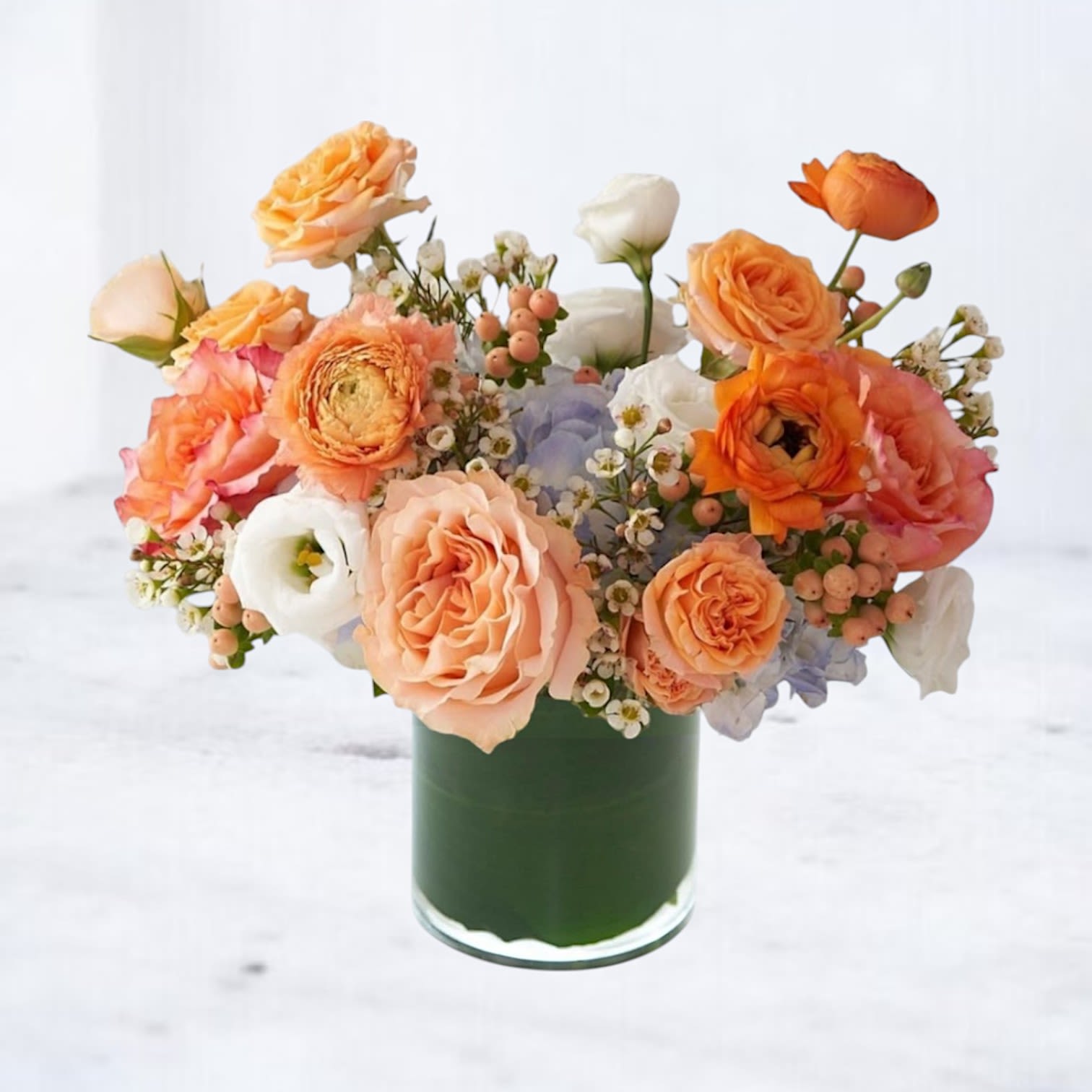 Clementide - Clementide – Peach &amp; Tangerine Flower Arrangement for Thoughtful Moments  Clementide is a radiant blend of peach roses, tangerine ranunculus, creamy lisianthus, and seasonal textural accents — a sunlit arrangement that exudes warmth, softness, and quiet charm. Designed to brighten someone’s day, this bouquet is perfect for celebrating friendships, sending a gentle “thinking of you,” or welcoming new beginnings with beauty and grace.  With its soft citrus tones and serene presence, Clementide makes a thoughtful gift that feels as comforting as it is elegant.